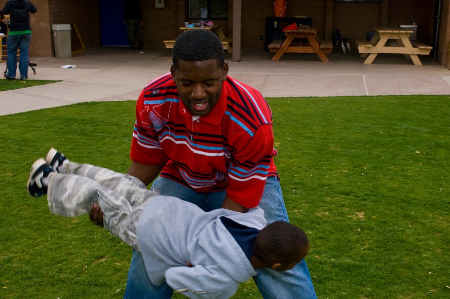 Senior Airman Earnest Hooks, 62nd Fighter Squadron Aviation Resource Management airman, plays "rocket ship" with children at the Childrens Crisis Nursery center, Feb 27, 2010. Luke members volunteer to visit the children once a month. (U.S. Air Force Photo by Staff Sgt. Jason Colbert)