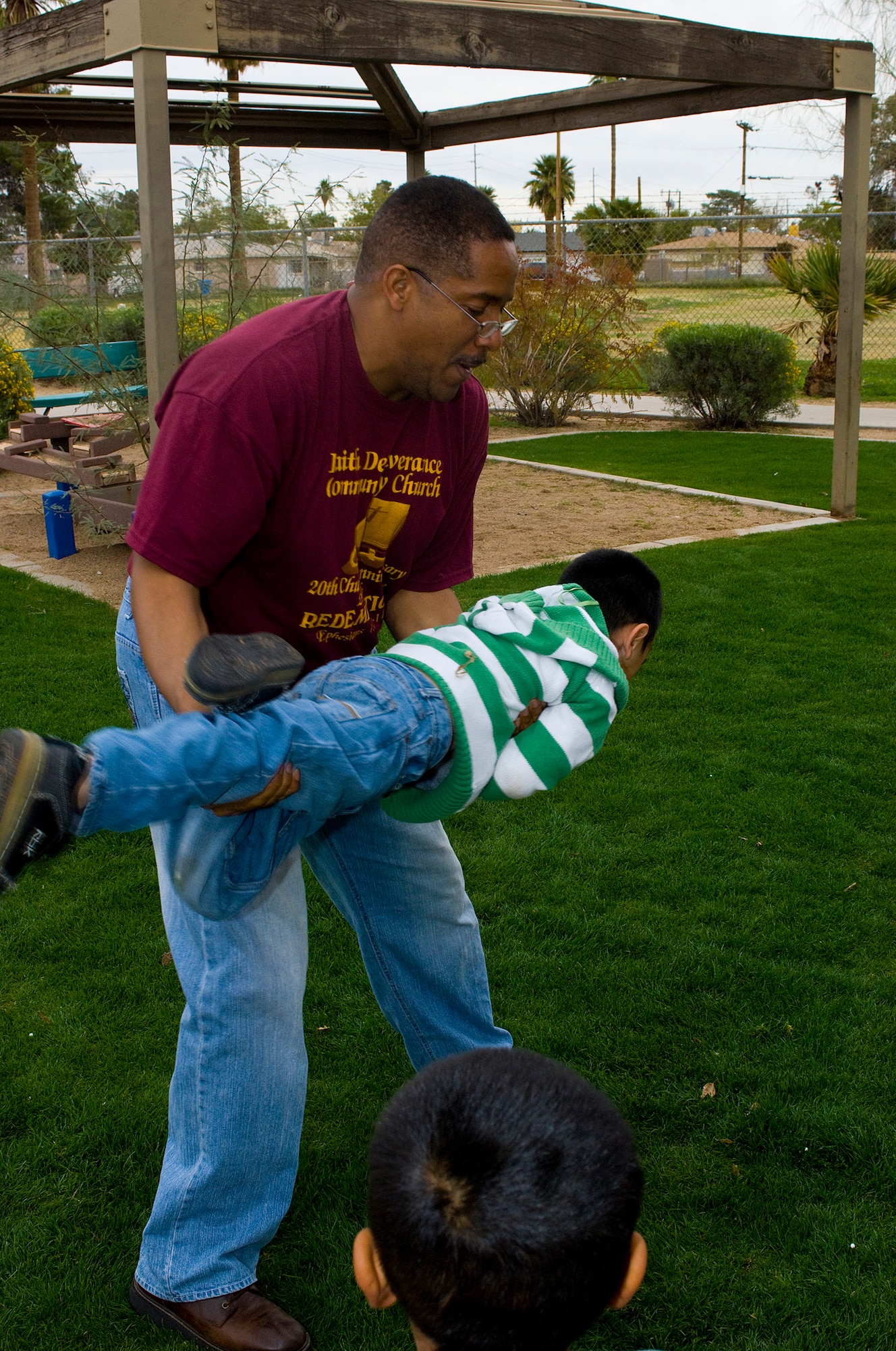 Senior Master Sgt.Marlin Hill, 56th Force Support Squadron Superintendent, plays "rocket ship" with children at the Childrens Crisis Nursery center, Feb 27, 2010. Luke members volunteer to visit the children once a month. (U.S. Air Force Photo by Staff Sgt. Jason Colbert)
