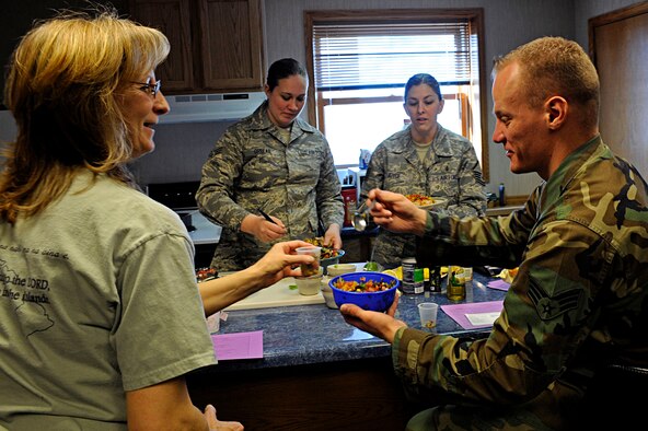 ELLSWORTH AIR FORCE BASE, S.D. -- (Right) Senior Airman Jason Hawkinberry, 28th Maintenance Squadron avionics test system journeyman, gives another serving of salsa to Mrs. Lori Parrish, wife of Chaplain (Maj.) James Parrish, during a heart-healthy recipe demonstration presented by the Health and Wellness Center, Feb. 26. The HAWC representatives provided participants with multiple recipes designed for a heart-healthy diet. (U.S. Air Force photo/Airman 1st Class Matthew Flynn)