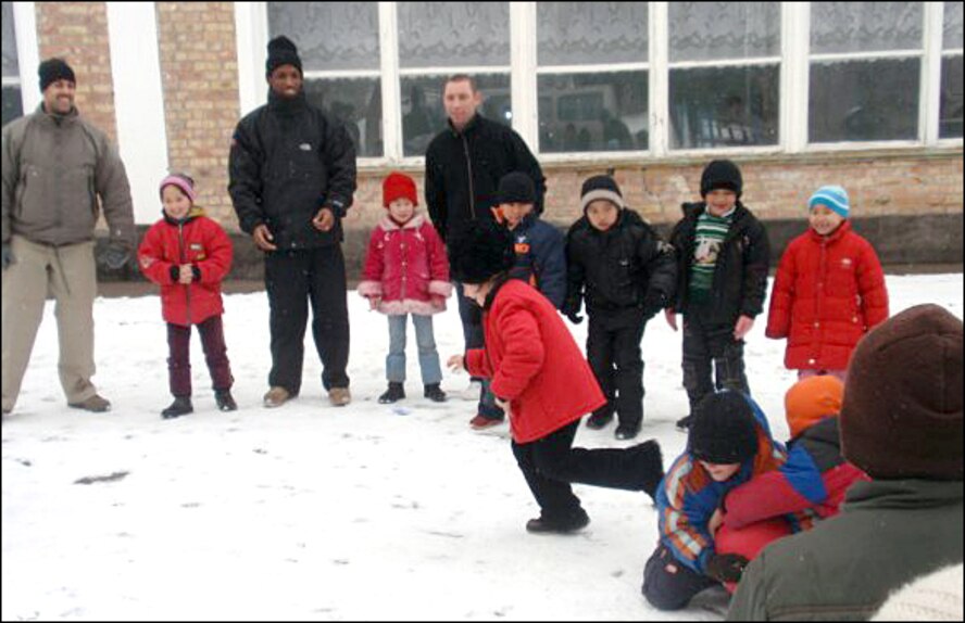 Service members from the Transit Center at Manas play with children at the Nizhanchuisk Orphanage. (U.S. Air Force photo)