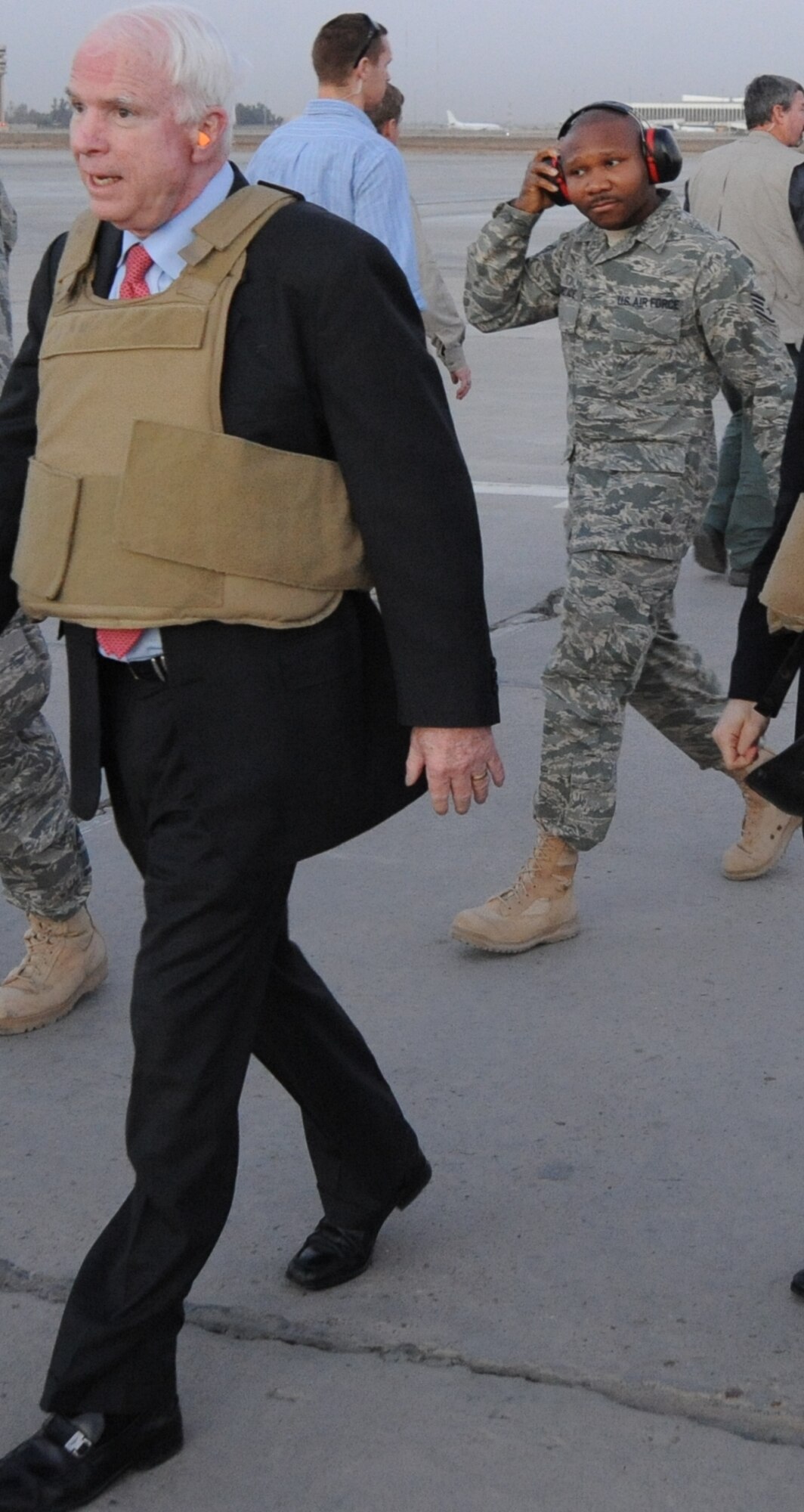 SATHER AIR BASE, Iraq -- Staff Sgt. Azeez Oguntade, Headquarters Air Combat Command Protocol, escorts U.S. Senator John McCain on the flight line during a visit to Iraq. Sergeant Oguntade is responsible for the transportation of distinguished visitors and celebrities in the area of responsibility. (Courtesy photo)
