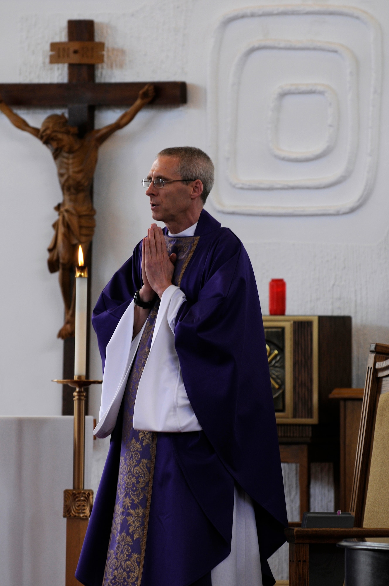 Capt. David McGuire, Chaplain, 86th Airlift Wing, prays during a mass in the North Side Chapel, Ramstein Air Base, Germany, Feb. 25, 2010. Capt. McGuire was a pastor for The Catholic Diocese of Richmond, Va., before joining the Air Force in 2007. "I wanted to contribute and help active duty members and their families," said Capt. McGuire. (U.S. Air Force photo by Airman 1st Class Brittany Perry)