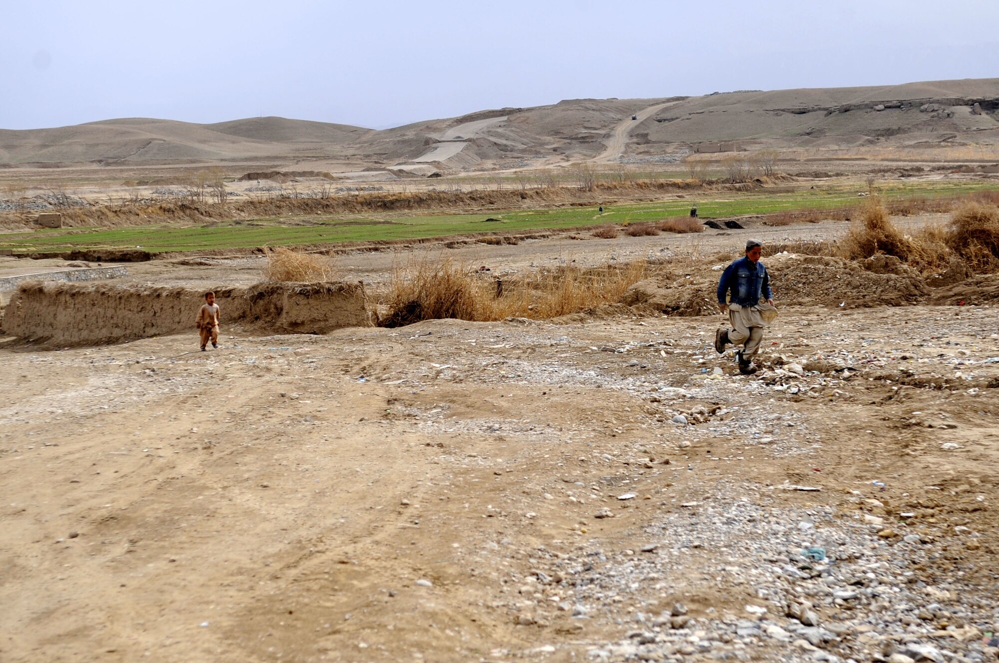 Afghan children run towards the opening of the Sheik Mati Boy's High School Feb. 25 in Qalat city of the Zabul Province in Afghanistan. Most families live in communities located quite a distance from the city.  The new dormitory can house 240 boys, making school a possibility for them.  (U.S. Air Force photo by Senior Airman Nancy Hooks)