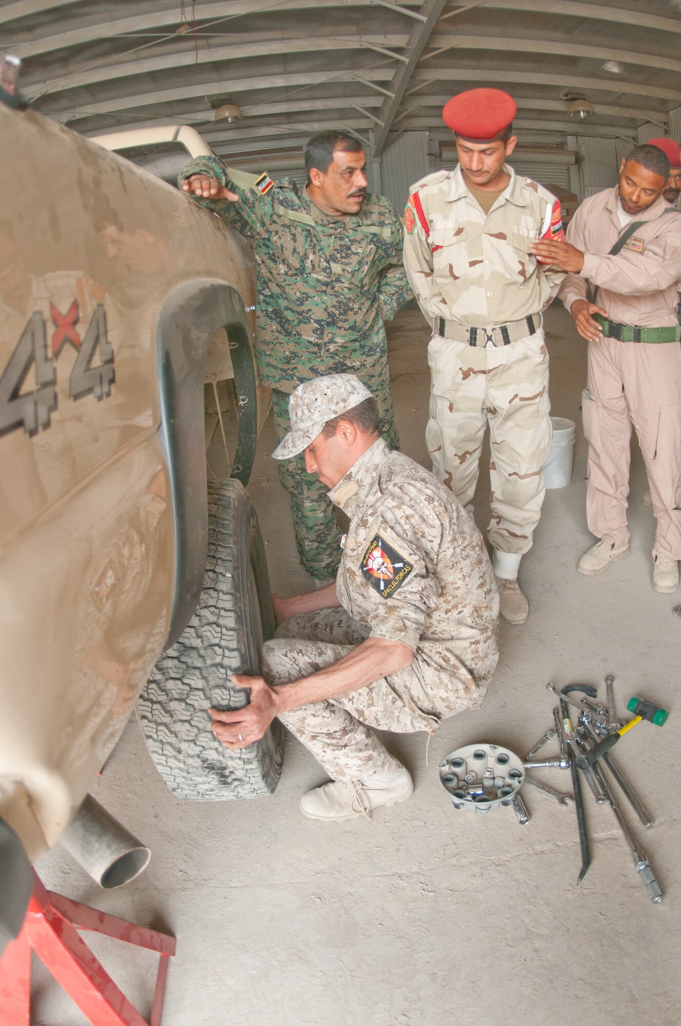 U.S. Air Force Tech Sgt. Damien Moody, 407th Expeditionary Logistics Readiness Squadron, Ali Base, Iraq deployed from 96th Logistics Readiness Squadron deployed from Eglin AFB, Florida, trains Iraqi Army soldiers how to properly remove a flat tire during a training course given by the Logistics Military Advisory Team at Camp Ur, Iraq, Feb. 22, 2010. Sgt Fish is from Joliet Ill. (Photo by Senior Master Sgt. Elizabeth Gilbert/released)