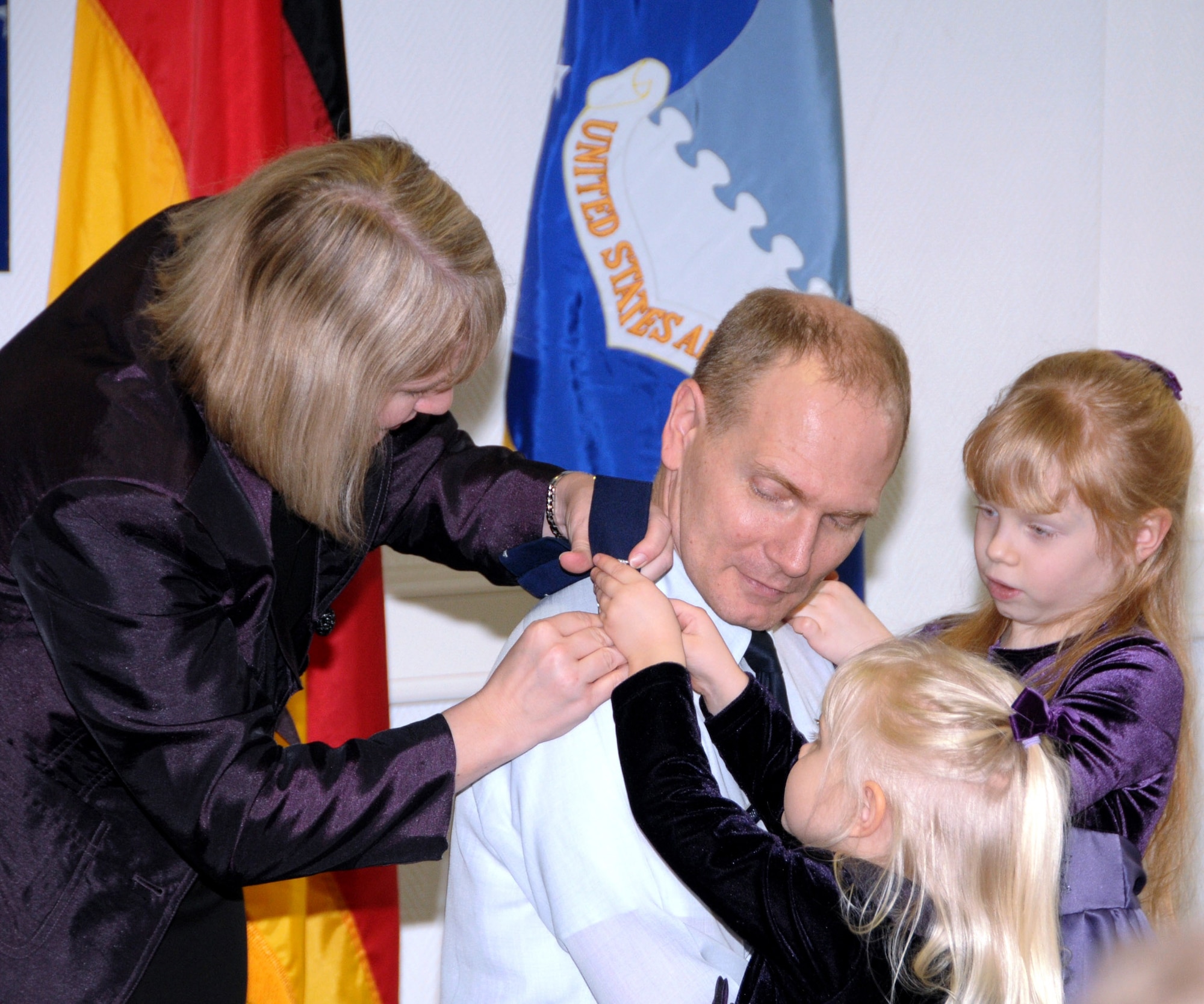 Col. Douglas Barron receives assistance from his wife, Medina (left) and daughters, Contessa (center) and Noella (right), in pinning on his eagles during his promotion ceremony Feb. 26, here. Colonel Barron is the Director, A6 (Communications) for 17th Air Force (Air Forces Africa). (U.S. Air Force photo by Master Sgt. Jim Fisher)