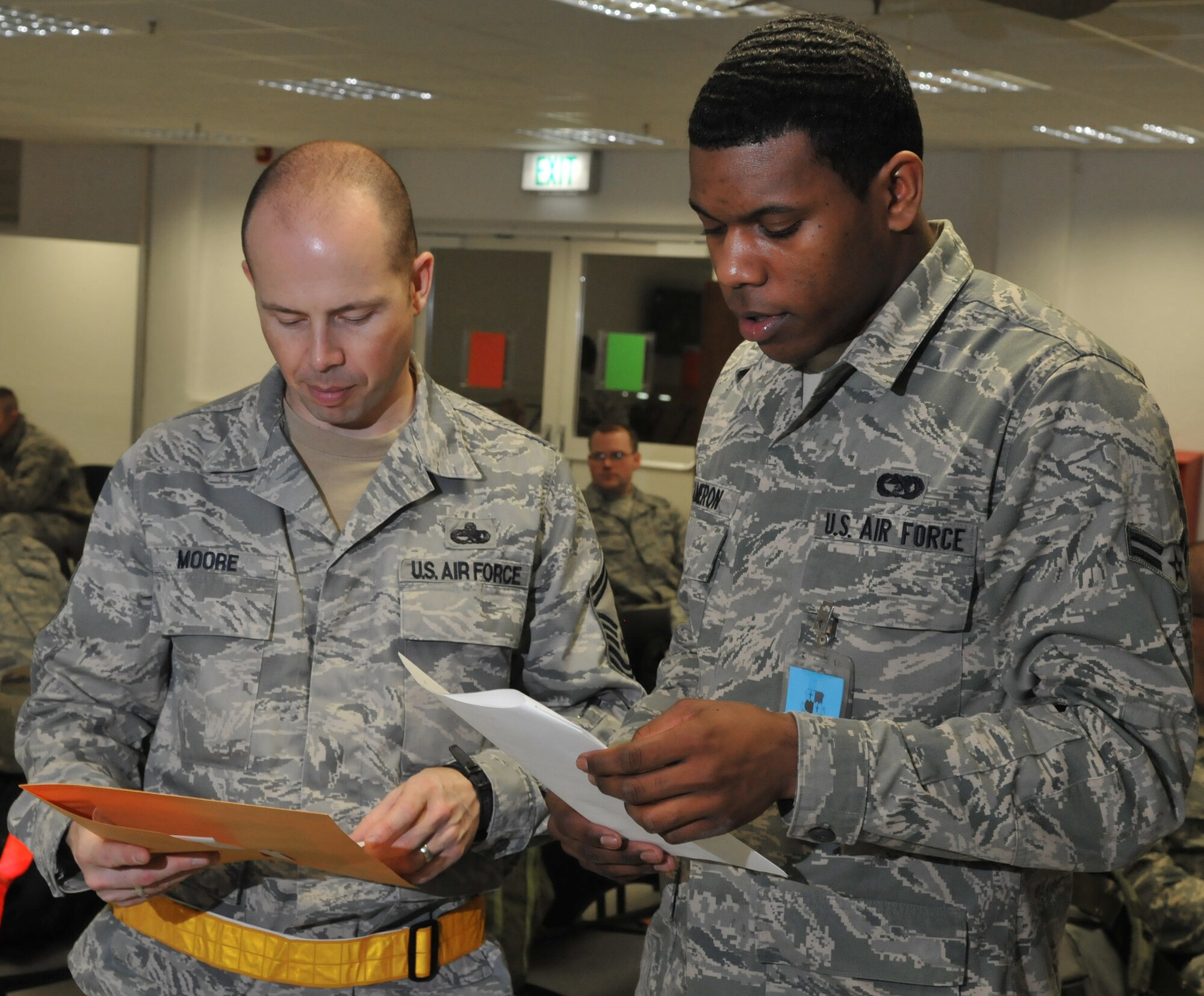 SPANGDAHLEM AIR BASE, Germany –  Airman 1st Class Aubrey Cameron, right, 52nd Logistics Readiness Squadron travel management office journeyman, briefs Senior Master Sgt. William G. Moore, 52nd Component Maintenance Squadron superintendent, on deployment responsibilities during a Phase I operational readiness exercise Feb. 25. The exercise evaluated the 52nd Fighter Wing’s ability to prepare for a real-world rapid deployment of personnel and assets to a forward-operating base.   (U.S. Air Force photo/Airman 1st Class Nick Wilson)