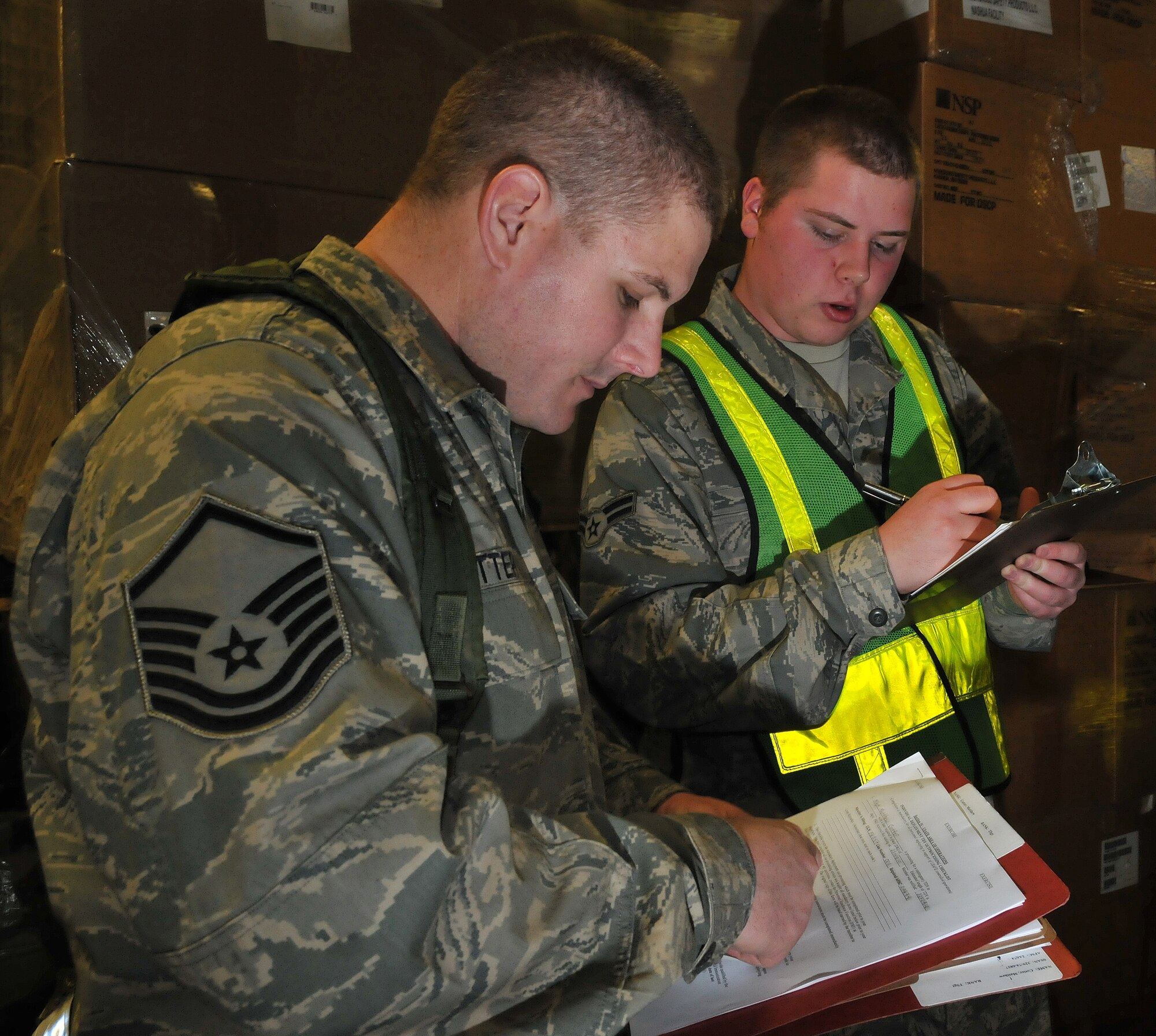 SPANGDAHLEM AIR BASE, Germany –  Master Sgt. Matthew Cotter, left, 52nd Component Maintenance Squadron aircraft field system repairman, receives simulated gear from Airman 1st Class Nicholas Pease, 52nd  Logistics Readiness Squadron supply journeyman, at a personnel deployment function line during a Phase I operational readiness exercise Feb. 25.  The exercise focused on personnel deployment function lines, emergency management and overall timeliness in responding to mission necessity. The PDF line is part of the pre-deployment checklist Airmen must go through to ensure they have all the proper documentation, medical clearances and requirements to deploy. (U.S. Air Force photo/Airman 1st Class Nick Wilson)