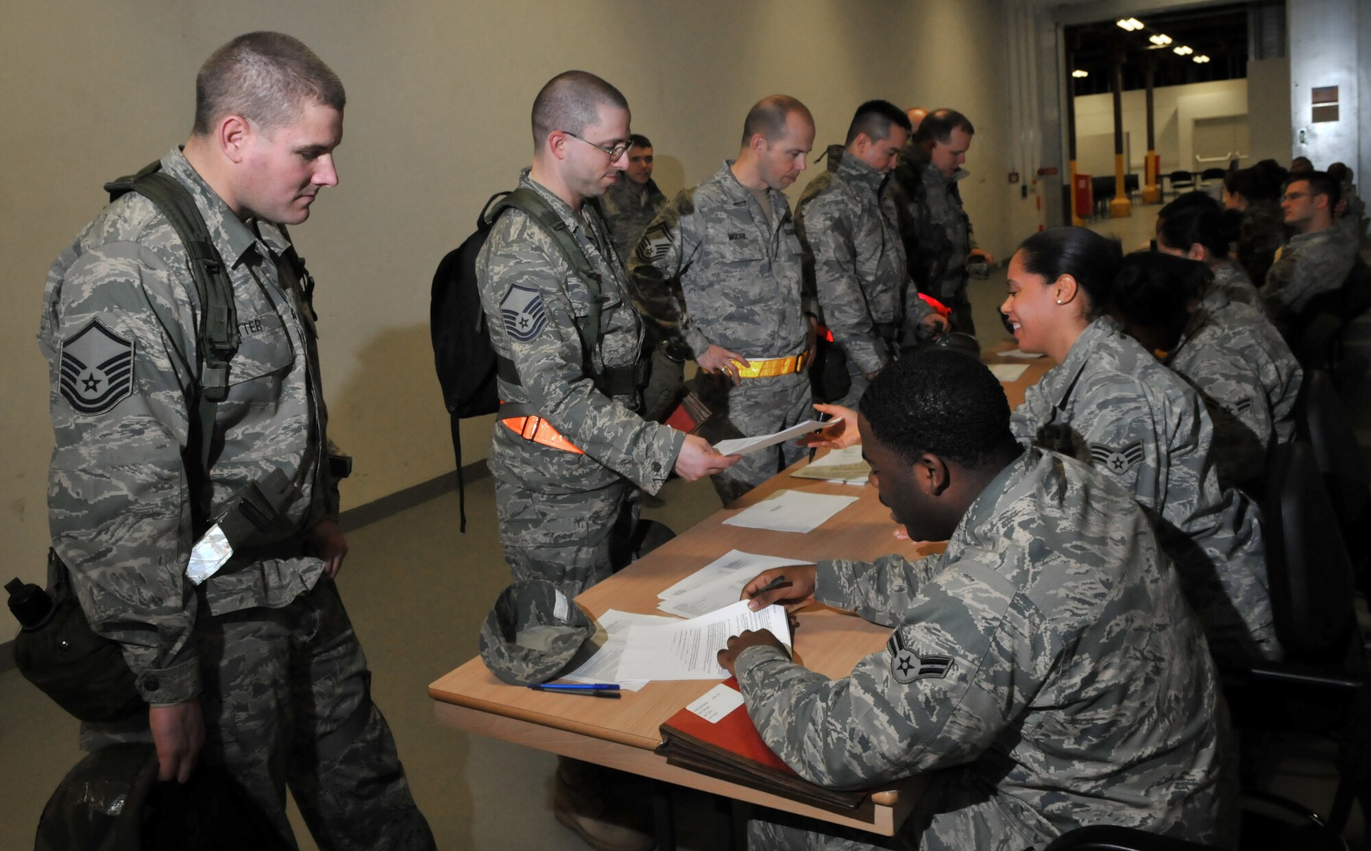 SPANGDAHLEM AIR BASE, Germany –Members of the 52nd Fighter Wing process through a simulated personnel deployment function line during a Phase I operational readiness exercise Feb. 25. The PDF line is part of the pre-deployment checklist Airmen must go through to ensure they have all the proper documentation, medical clearances and requirements to deploy. (U.S. Air Force photo/Airman 1st Class Nick Wilson)