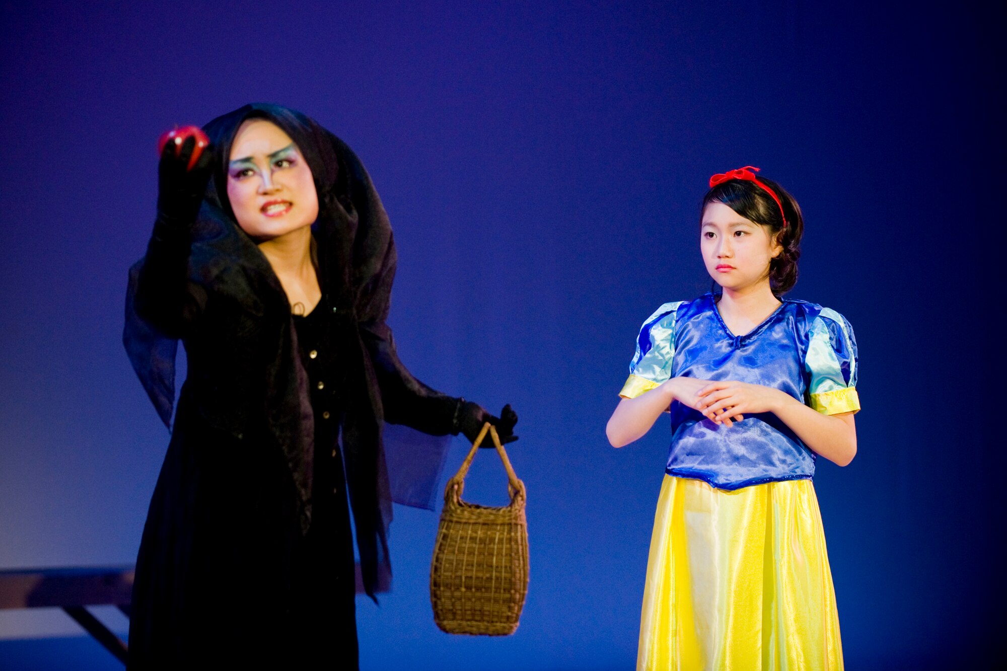 MISAWA CITY, Japan -- The Queen, played by Aiko Kudo, prepares to give a poisonous apple to Snow White, played by Ami Saishita, during a musical rendition of "Snow White" Feb. 28 at the Misawa International Center. With a theme of everlasting love, the musical contained singing, dancing and performances with musical instruments. (U.S. Air Force photo/Senior Airman Jamal D. Sutter)