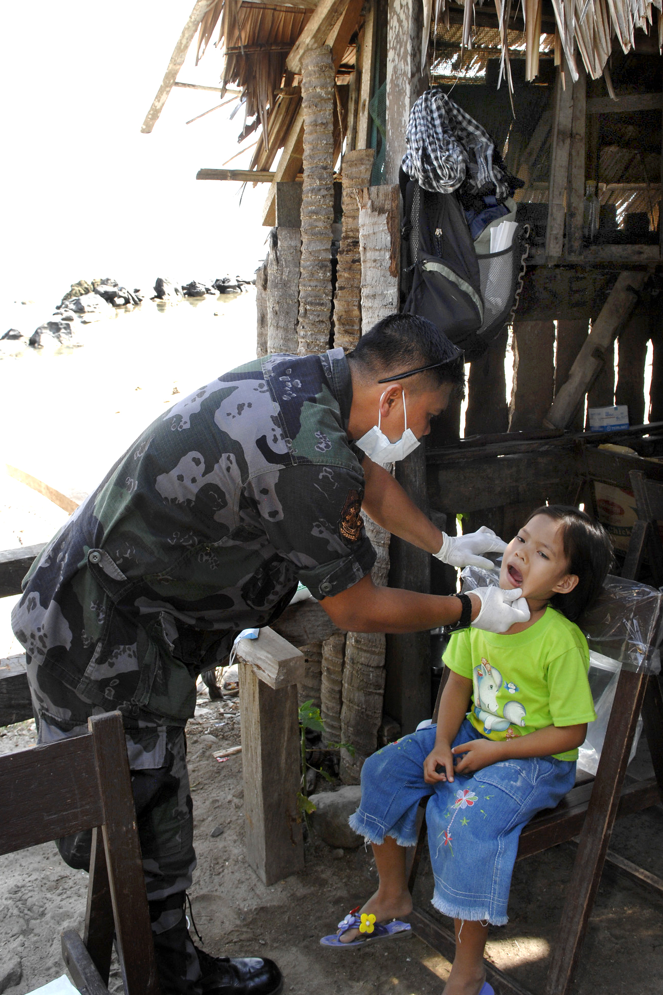 A dentist with the Philippine army examines a young girl during a