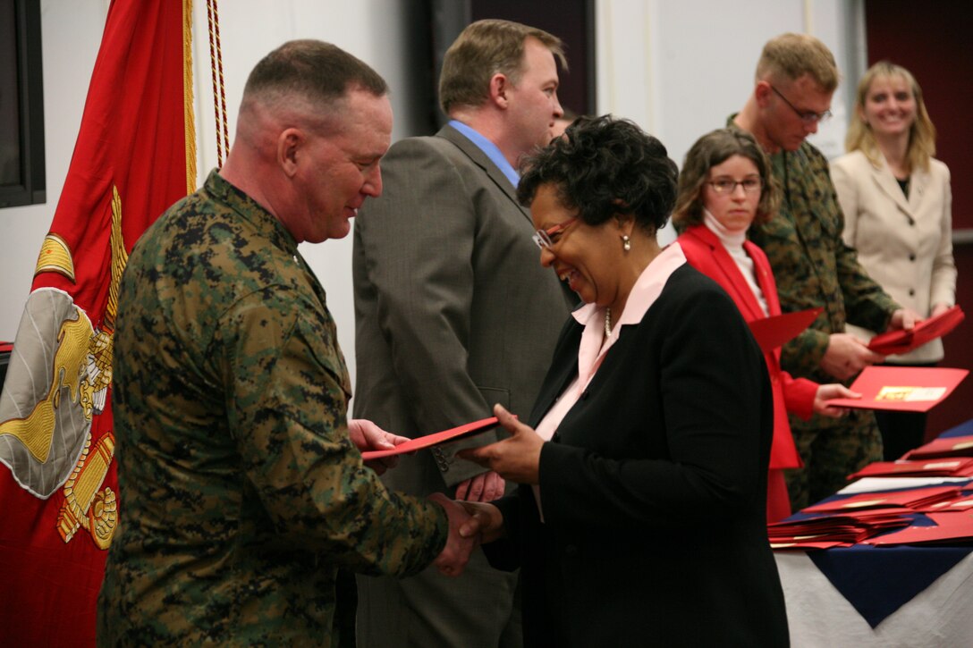 Col. Douglas A. Denn, Cherry Point’s commanding officer, hands Virginia Parks her Individual Development Plan completion certificate during the annual civilian Marine awards ceremony, March 2. The ceremony recognized civilians who have made significant accomplishments over the past year.