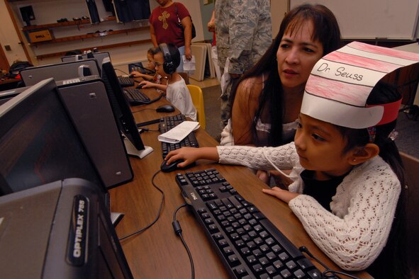 Marian and Marigail Reyna play a Dr. Seuss children's computer learning game as part of Kadena Elementary School's Dr. Suess birthday celebration March 2. Dozens of students and parents celebrated the famous author's birthday with a series of games and activities including eating green eggs and ham. (Air Force photo/Staff Sgt. Jason Lake)