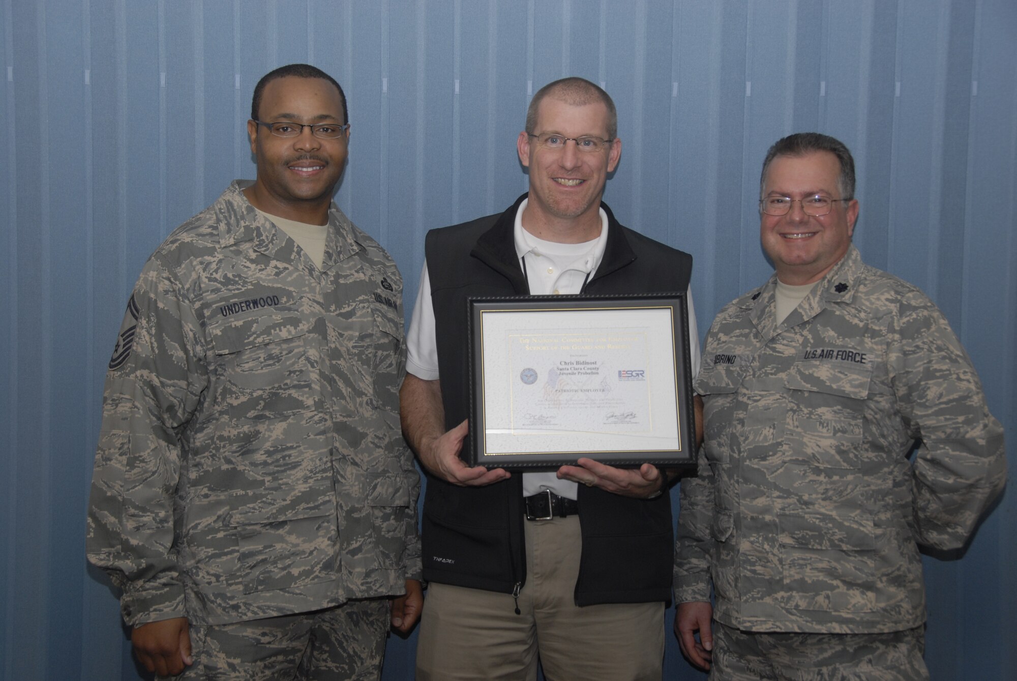 Chris Bidinost (center), supervising probation officer with the Santa Clara County Juvenile Probation Department's Alternative Placement Academy, was awarded the Department of Defense's National Committee for Employer Support of the Guard and Reserve’s Patriot Award during a ceremony in San Jose Feb. 24 by employee Senior Master Sgt. Christopher Underwood (left), 129th Rescue Wing’s human resource advisor and Lt. Col. Pete Sobrino (right), 129th executive officer. (Air National Guard photo by Staff Sgt. Kim Ramirez)