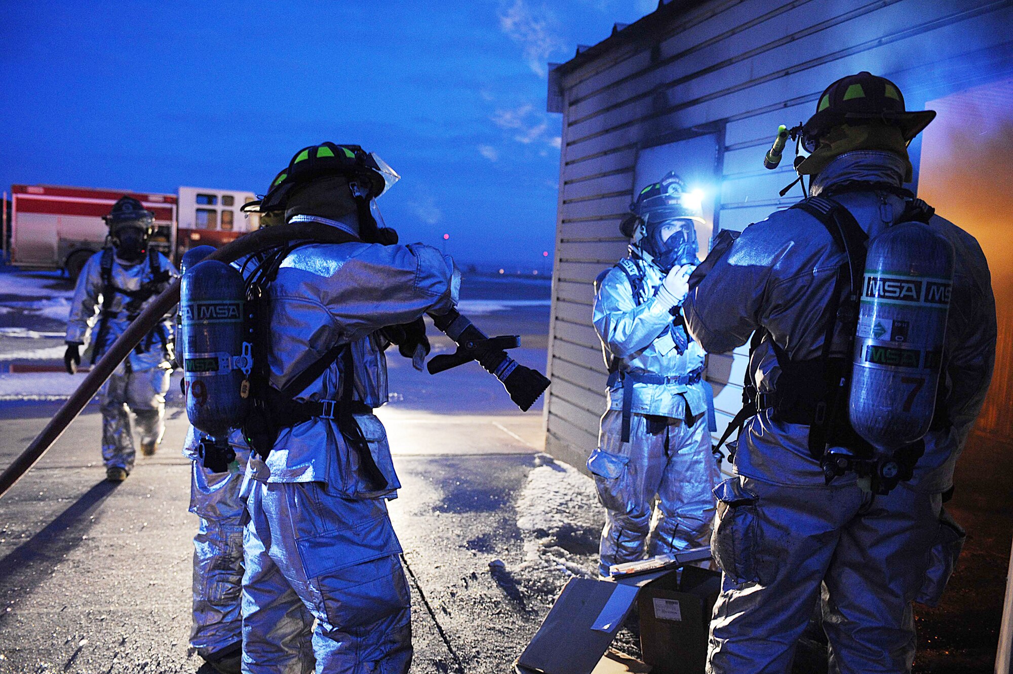 Firefighters from the 28th Civil Engineer Squadron gather outside a house "fire" before they start their training exercise, Feb. 17, 2010, at Ellsworth Air Force Base, S.D. The 28 CES fire department practices various training scenarios to maintain readiness qualifications. (U.S. Air Force photo/Airman 1st Class Corey Hook)