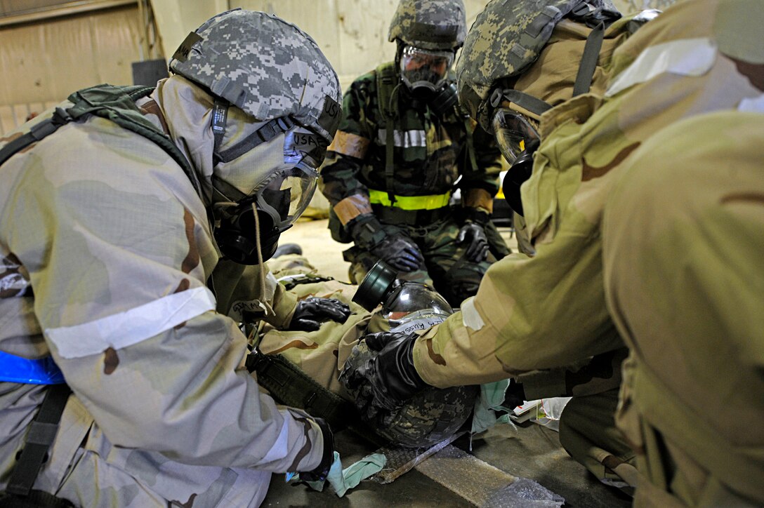ELLSWORTH AIR FORCE BASE, S.D. -- Airmen from the 28th Logistics Readiness Squadron provide Self-Aid Buddy Care to a simulated "victim" during a Phase II Operational Readiness Exercise while in Mission Oriented Protective Posture gear, March 2. MOPP 4 gear consists of chemical and biological warfare jacket and pants, protective rubber boots, rubber gloves, helmet and gas mask. (U.S. Air Force photo/Airman 1st Class Matthew Flynn)