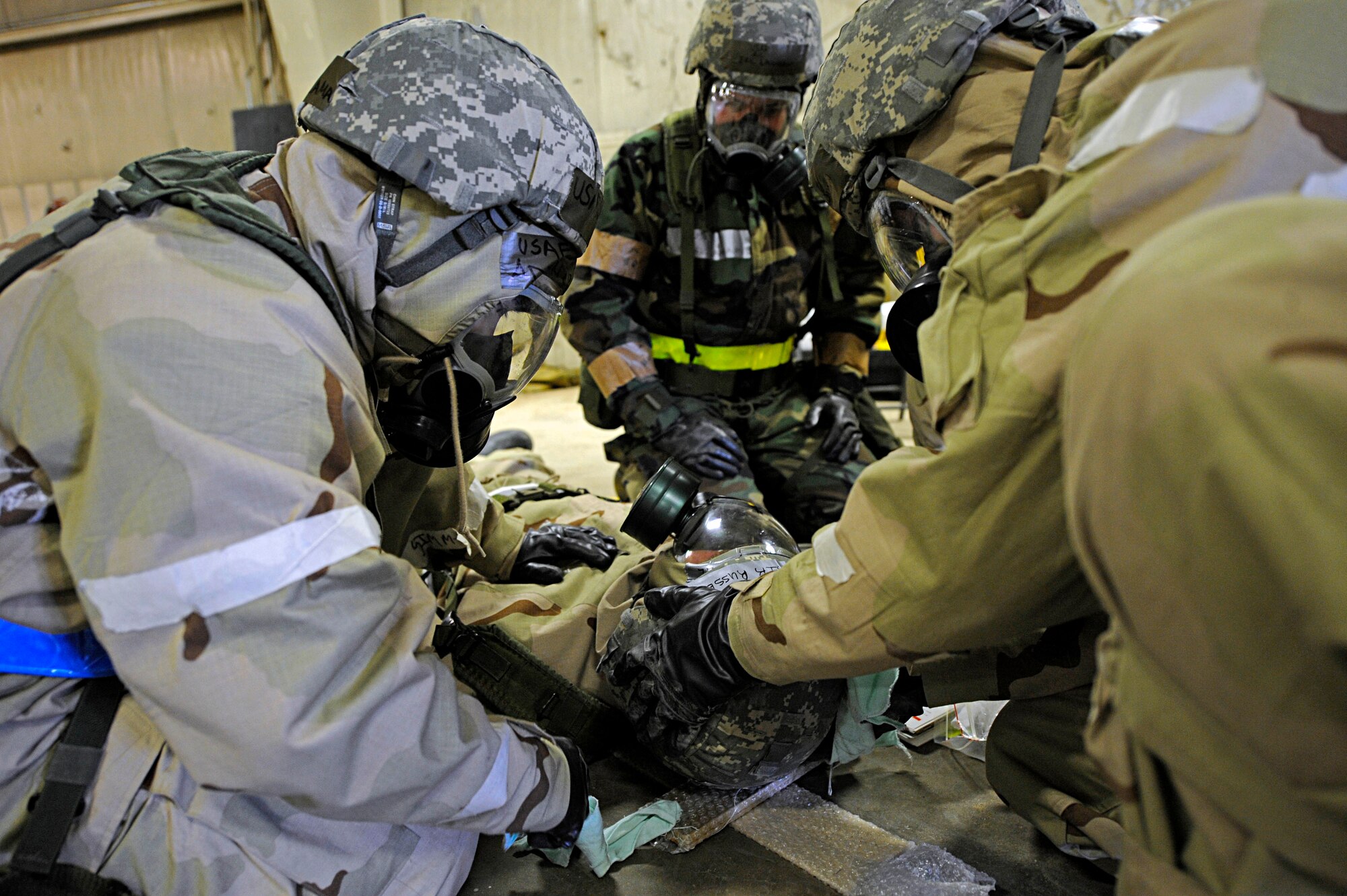 ELLSWORTH AIR FORCE BASE, S.D. -- Airmen from the 28th Logistics Readiness Squadron provide Self-Aid Buddy Care to a simulated "victim" during a Phase II Operational Readiness Exercise while in Mission Oriented Protective Posture gear, March 2. MOPP 4 gear consists of chemical and biological warfare jacket and pants, protective rubber boots, rubber gloves, helmet and gas mask. (U.S. Air Force photo/Airman 1st Class Matthew Flynn)