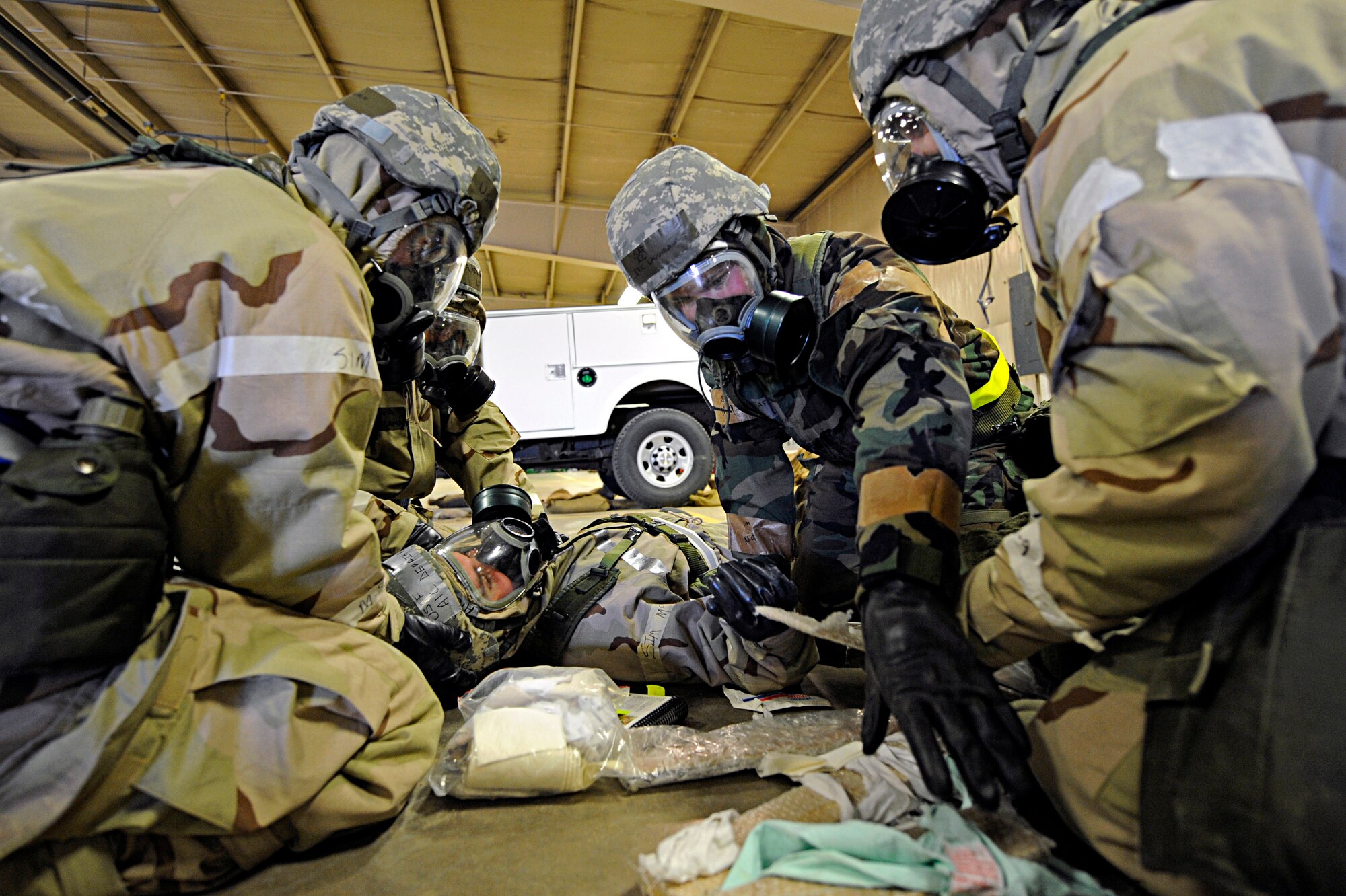 ELLSWORTH AIR FORCE BASE, S.D. -- Airmen from the 28th Logistics Readiness Squadron provide Self-Aid and Buddy Care to a simulated "victim" during a Phase II Operational Readiness Exercise while in Mission Oriented Protective Posture gear, March 2. MOPP 4 gear consists of chemical and biological warfare jacket and pants, protective rubber boots, rubber gloves, helmet and gas mask. (U.S. Air Force photo/Airman 1st Class Matthew Flynn)