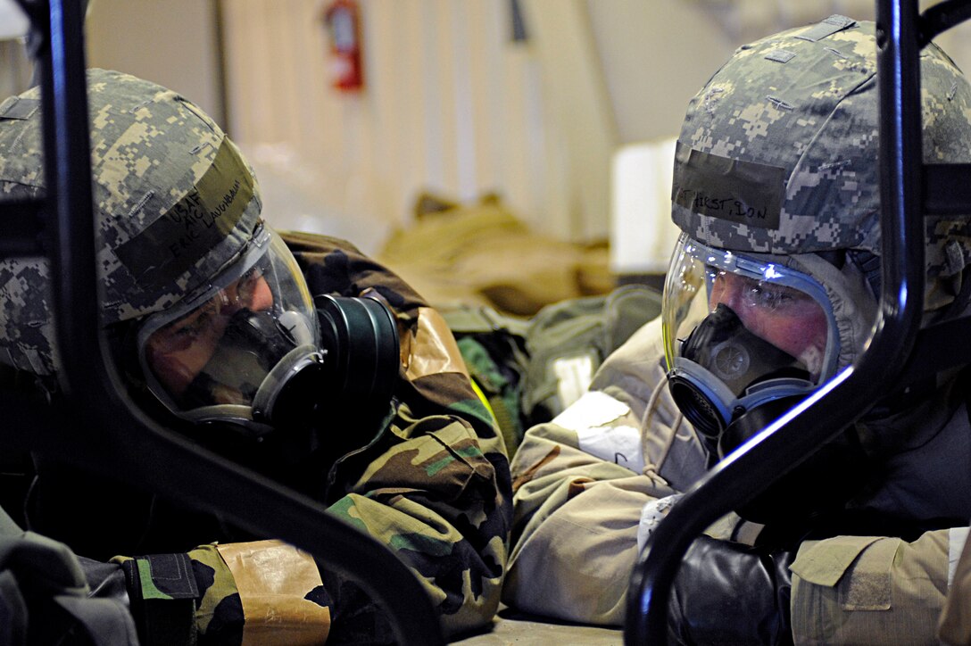 ELLSWORTH AIR FORCE BASE, S.D. -- (Left) Airman 1st Class Eric Laughbaum, 28th Logistics Readiness Squadron vehicle maintenance technician, and Tech. Sgt. Don Hirst, 28 LRS lightweight vehicles assistant NCO-in charge, take cover after an alarm red is sounded during a Phase II Operational Readiness Exercise, March 2. The Phase II ORE tested Airmen across the base on their readiness in a deployed environment. (U.S. Air Force photo/Airman 1st Class Matthew Flynn)