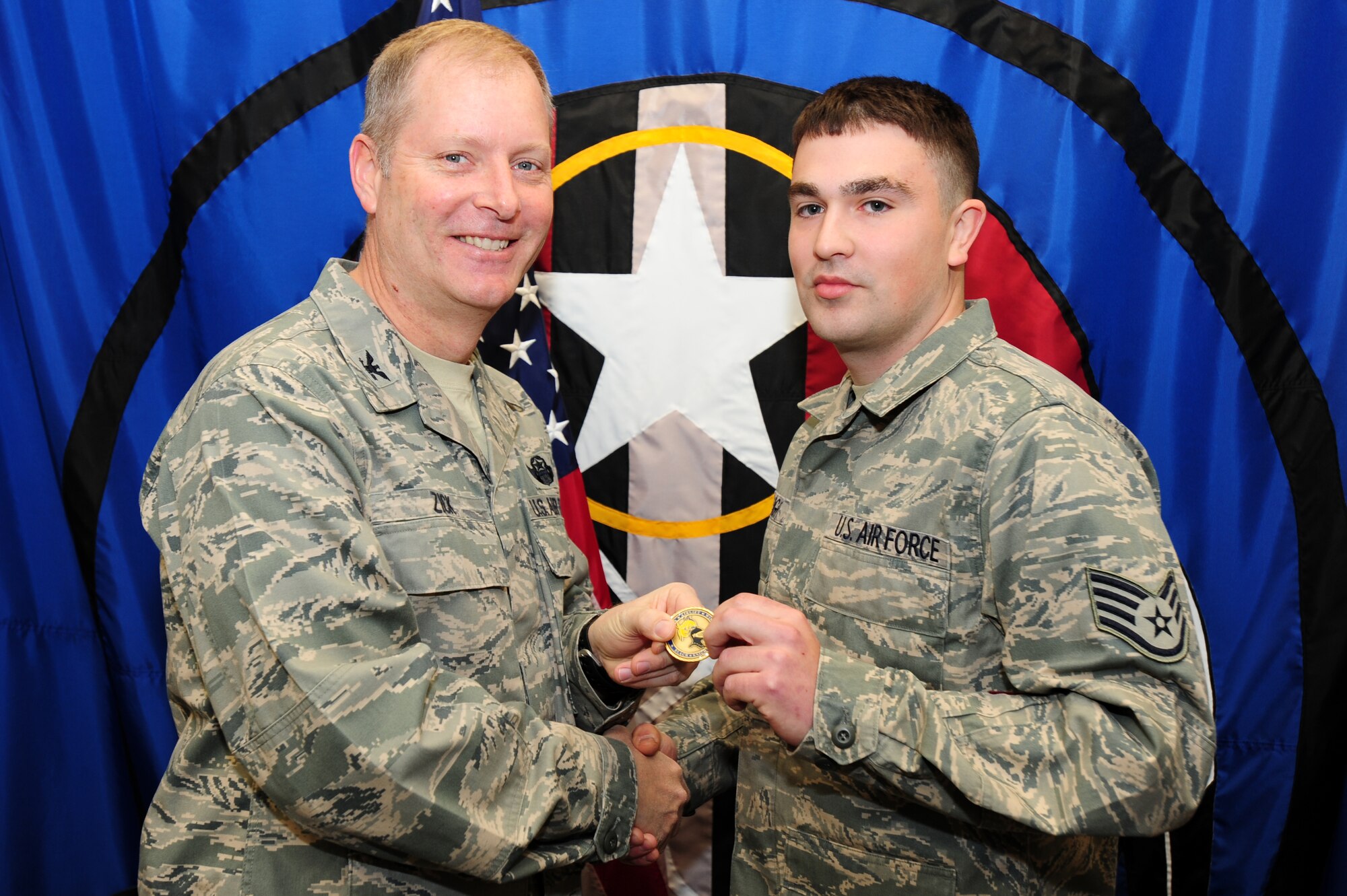 Col. Michael Zick, 19th Airlift Wing vice commander, presents a coin to Staff Sgt. Bruce Wright, a 29th Weapons Squadron knowledge operations manager, for being the Combat Airlifter of the Week. (U.S. Air Force photo by Senior Airman Steele C. G. Britton)