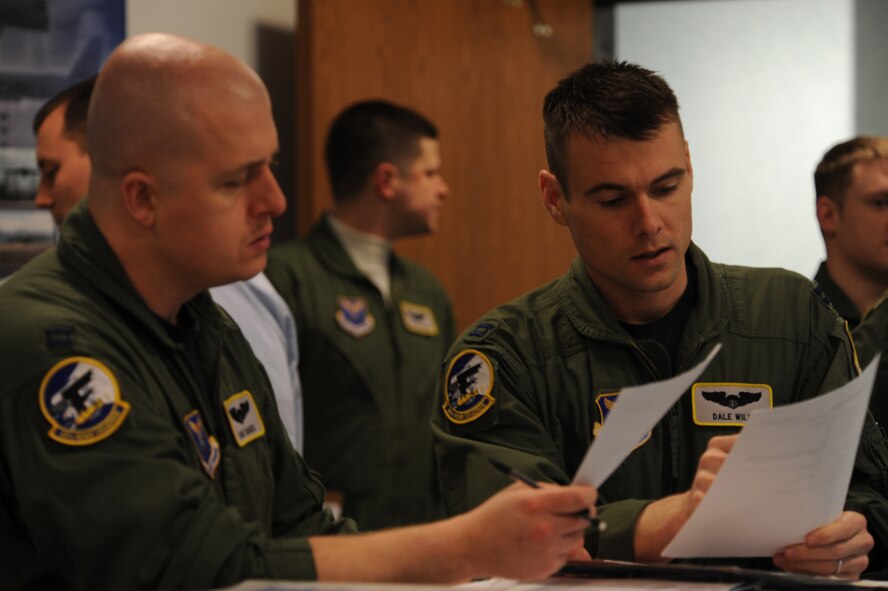 MINOT AIR FORCE BASE, N.D. - Capt. Chad Davies (left) and Capt. Dale Wilds, both 69th Bomb Squadron pilots, review their flight plan before a training mission March 1. The 69th continues with its mission of conducting safe, secure and reliable nuclear operations.(U.S. Air Force Photo by Tech. Sgt. Lee A. Osberry Jr.)

