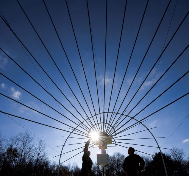 Master Sgt. Yolanda Hernandez, left, and Staff Sgt. Stephen S. Ensminger, electronic systems maintainers, stand under the sweeping dipoles on a Solar Radio Spectrograph. The SRS measures radio wavelengths between 25-75 MHz.  (U.S. Air Force photo/Lance Cheung)