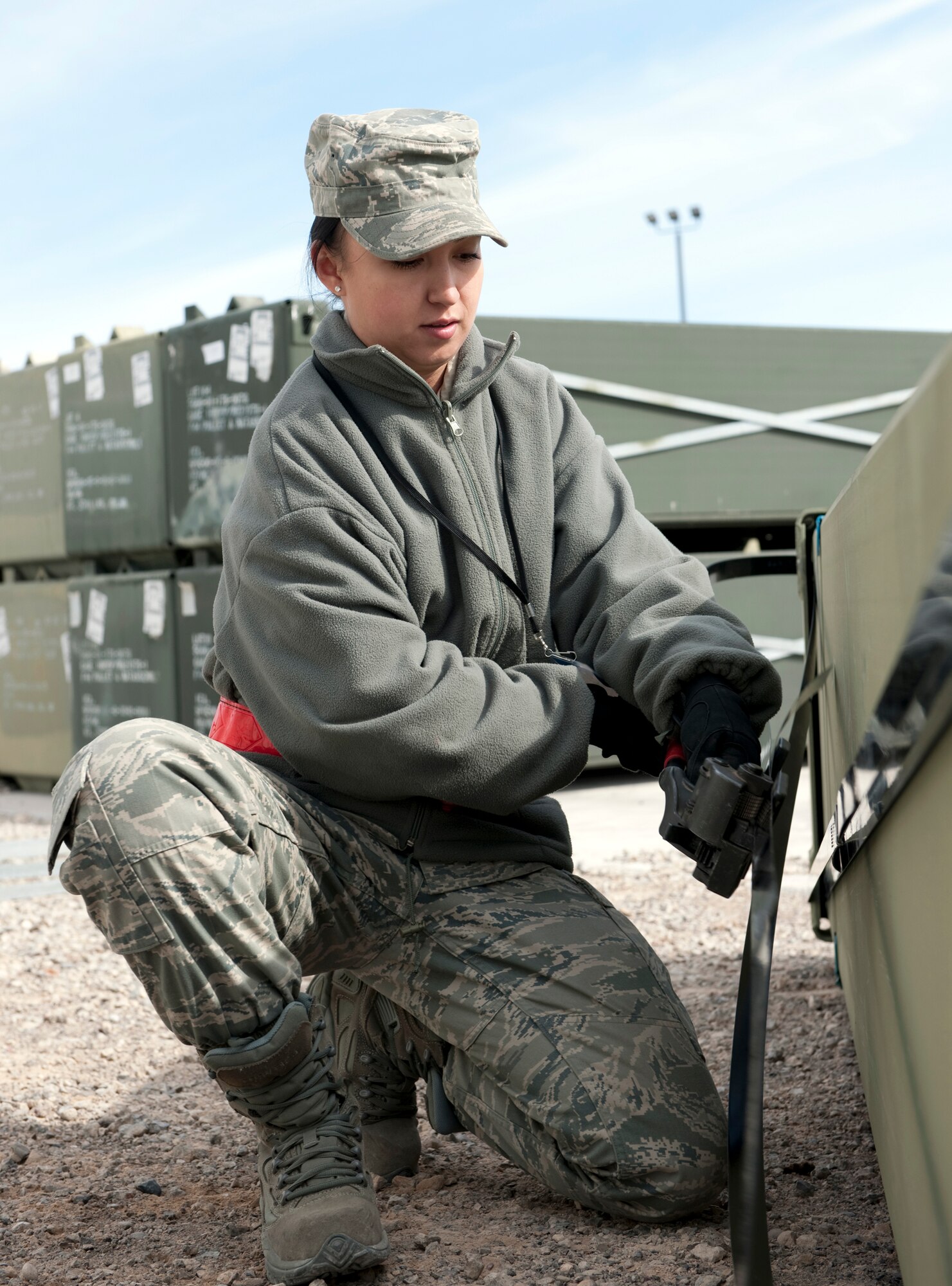 Airman 1st Class Olga Apairna installs steal straps on a container of AM-2 matting prior to its shipment to Afghanistan Feb. 24, 2010, at Holloman Air Force Base, N.M. Airman Apairna is assigned to the 49th Materiel Maintenance Support Squadron. The 49th MMSS is deploying 480,000 square feet of the matting that will be assembled to create airstrips supporting joint and coalition forces throughout Afghanistan. (U.S. Air Force photo/Staff Sgt. Joe Laws)
