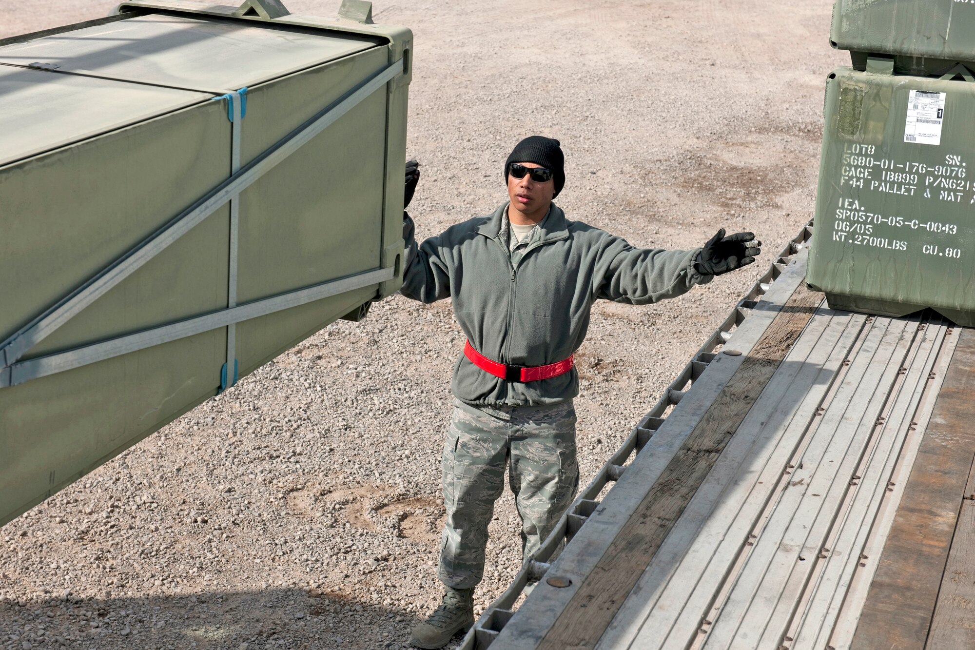 Airman 1st Class Teddy Perez ground-guides a 13,000-pound loader carrying nearly 11,000 pounds of AM-2 matting onto a flatbed trailer Feb. 24, 2010, at Holloman Air Force Base, N.M. Airman Perez is assigned to the 49th Materiel Maintenance Support Squadron. The 49th MMSS is deploying 480,000 square feet of the matting that will be assembled to create airstrips supporting joint and coalition forces throughout Afghanistan. (U.S. Air Force photo/Staff Sgt. Joe Laws)