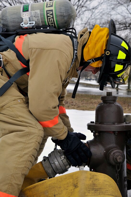 Colonel Steven Shepro, Joint Base Andrews/316th Wing commander, attaches a four inch supply line to a hydrant While working with the 316th Civil Engineer Squadron firefighters  Feb. 23, 2010 at Joint Base Andrews, Md. Colonel Shepro and his Airman "shadow" participated in a simulated structure fire with the fire department in an old housing unit. (U.S. Air Force photo by Airman 1st Class Perry Aston) (Released)