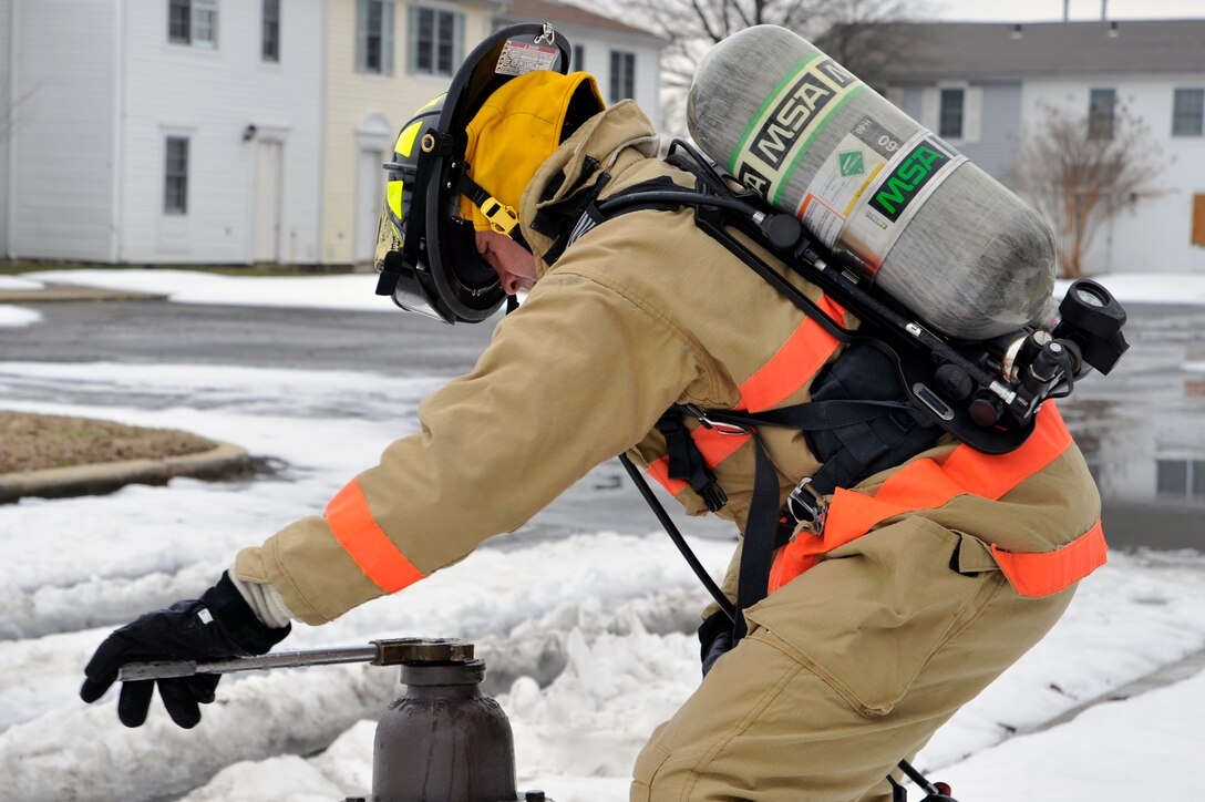 Colonel Steven Shepro, Joint Base Andrews/316th Wing commander, uses a hydrant wrench to open the hydrant so water can flow to an engine while working with the 316th Civil Engineer Squadron firefighters for a day Feb. 23, 2010 at Joint Base Andrews, Md. Colonel Shepro and his Airman "shadow" for the day participated in a simulated structure fire with the fire department in an old housing unit. (U.S. Air Force photo by Airman 1st Class Perry Aston) (Released)
