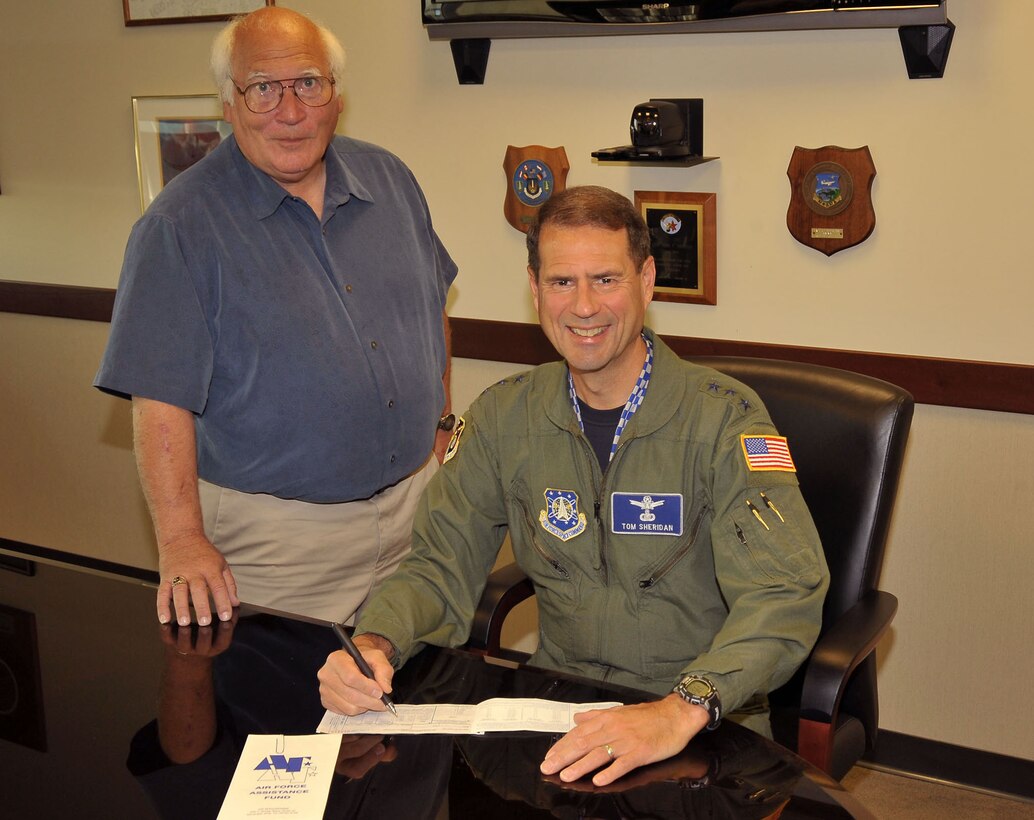 Lt. Gen. Tom Sheridan, SMC commander, signs a pledge form for this year’s Air Force Assistance Fund campaign while John Bohon, the base-wide AFAF coordinator, looks on.  Los Angeles AFB personnel can donate by making a payroll deduction, or a one-time cash or check contribution now through March 19.  AFAF benefits the Air Force Aid Society, Air Force Village Foundation, Air Force Enlisted Village and the General and Mrs. Curtis LeMay Foundation. (Photo by Lou Hernandez)