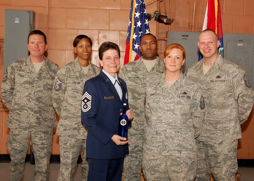 Chief Master Sgt Lisa Kessinger is presented a token of appreciation from the First Sergeants Council. during her retirement ceremony at Lambert Air National Guard Base on Feb 20. Pictured L-R: Senior Master Sgt. Eric Hugo, Master Sgt. Carla Hampton, Chief Master Sgt. Lisa Kessinger, Master Sgt. Sheldon Matthews, Master Sgt. Jennifer Rost, and Master Sgt. James Craig. (Photo by Staff Sgt. Amber Hodges)