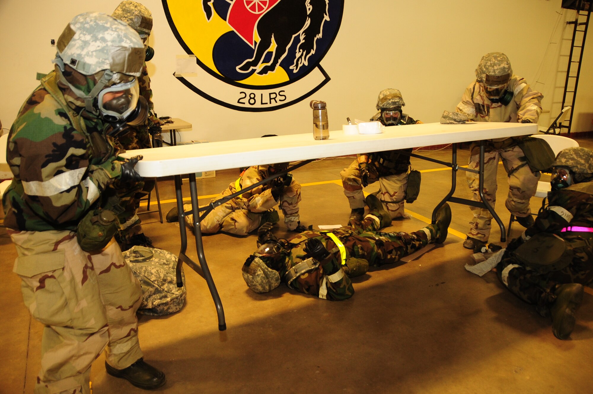 ELLSWORTH AIR FORCE BASE, S.D. -- Airmen from 28th Logistics Readiness Squadron move a table out of the way before addressing an Airman with a simulated compound fracture during a Phase II Operational Readiness Exercise, March 2.  The Phase II ORE is designed to simulate a deployed environment and test the combat abilities, such as self-aid and buddy care, of Ellsworth's Airmen. (U.S. Air Force photo/Airman 1st Class Anthony Sanchelli)
