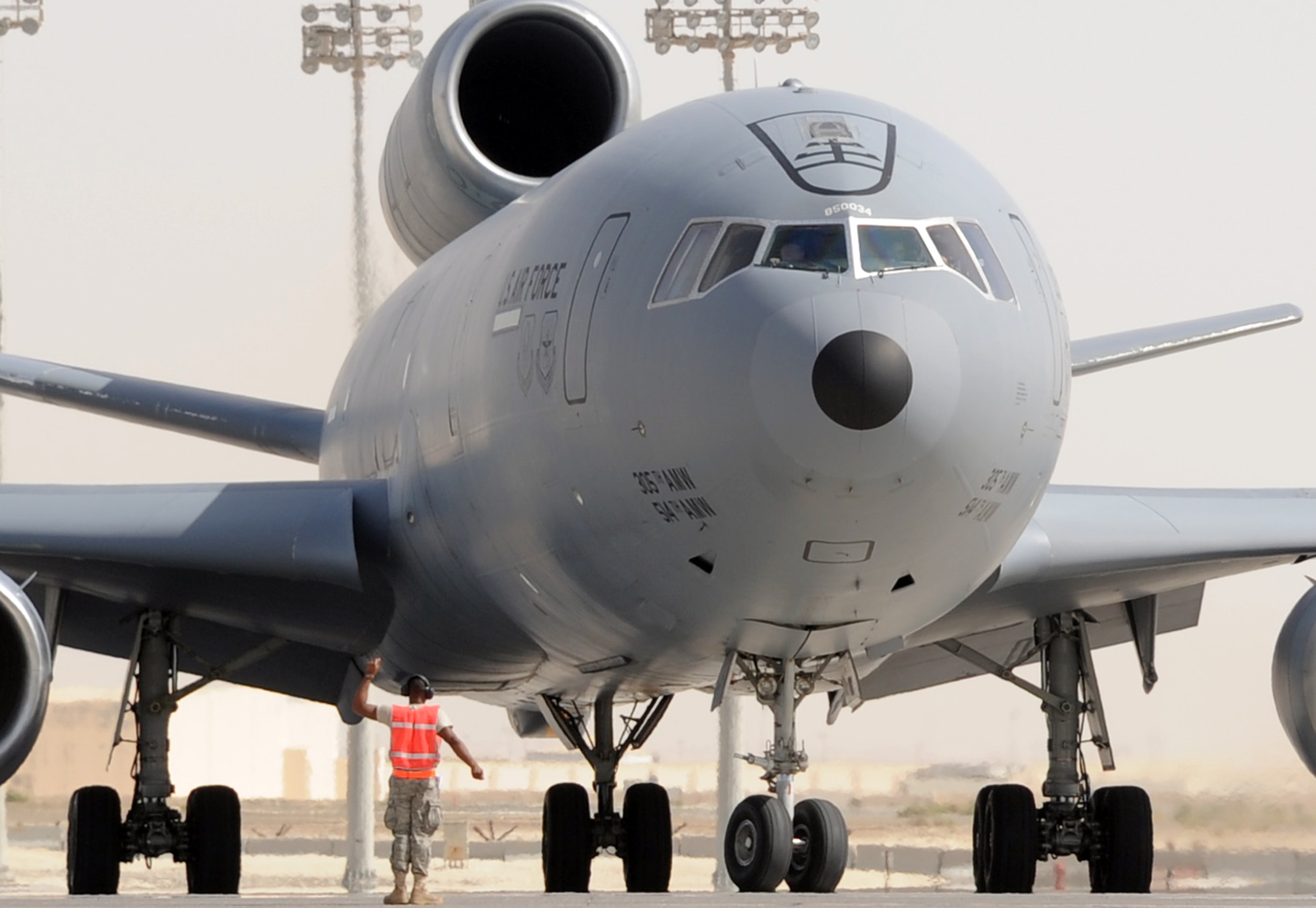 A maintenance Airman from the 380th Expeditionary Aircraft Maintenance Squadron Extender aircraft maintenance unit wait to guide a KC-10 Extender assigned to the 908th Expeditionary Air Refueling Squadron of the 380th Air Expeditionary Wing out for a mission during flightline operations at a non-disclosed base in Southwest Asia. In 2009, KC-10s from the 380th AEW and the 908th EARS flew 4,760 combat sorties offl-loading 422,222,300 pounds of fuel to 31,434 aircraft. In the same year, the KC-10s and their crews accumulated 40,011 hours of flight time. The 380th AEW and its units support operations Iraqi Freedom and Enduring Freedom and the Combined Joint Task Force-Horn of Africa. (U.S. Air Force Photo/Master Sgt. Scott T. Sturkol/Released)