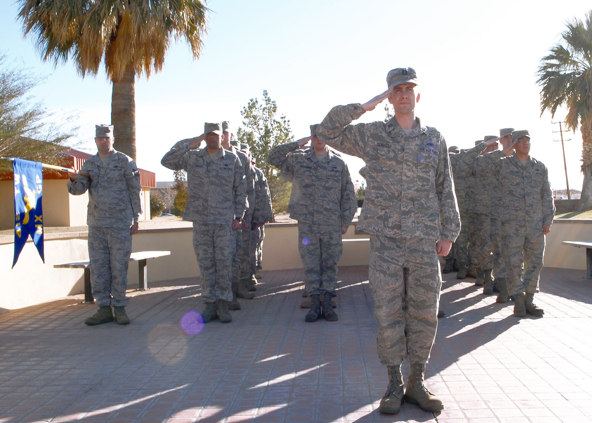 Capt. Clifford Scruggs, 412th Maintence Squadron Maintence Operations officer, leads a flight of Airmen in presenting arms during the lowering of the American Flag during a retreat ceremony in front of the Air Force Flight Test Center Headquarters Feb. 25. A retreat ceremony is held to mark the end of the duty day and honor the American Flag. (Air Force photo/Airman 1st Class William O'Brien)