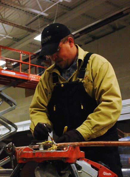 MINOT AIR FORCE BASE, N.D. -- Tobie Hansen, a journeyman plumber with a base contractor, prepares copper pipes for the walls of a new bay in the 91st Missile Wing headquarters building Feb 25. The contractors are adding a new bay so more tractor trailers can use the loading docks. (U.S. Air Force photo by Airman 1st Class Aaron-Forrest Wainwright)