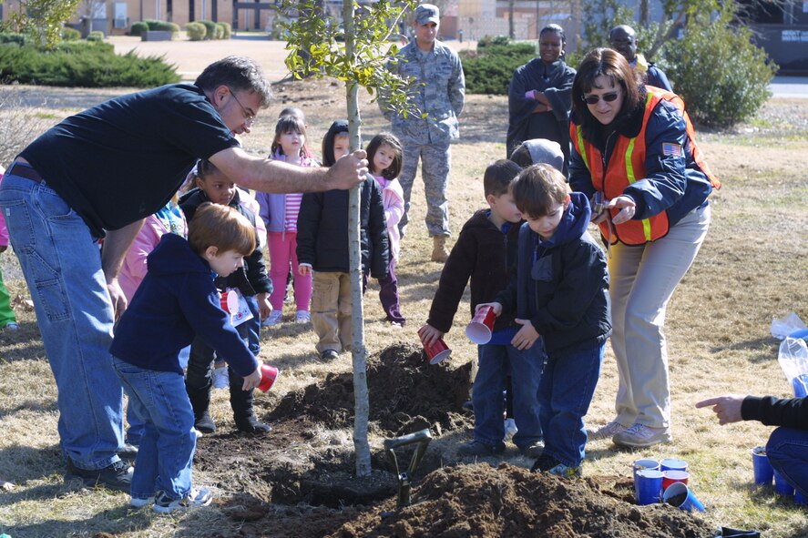 MOODY AIR FORCE BASE, Ga. -- In celebration of Arbor Day, approximately 36 pre-kindergarten children from the Child Development Center help John Crain, 23rd Civil Engineer Squadron base forester, plant a live oak tree near the Tree City, USA, flag pole here Feb. 19. During the event, the children also learned about the importance of trees for the environment. National Arbor Day will be celebrated April 30. (Courtesy photo)