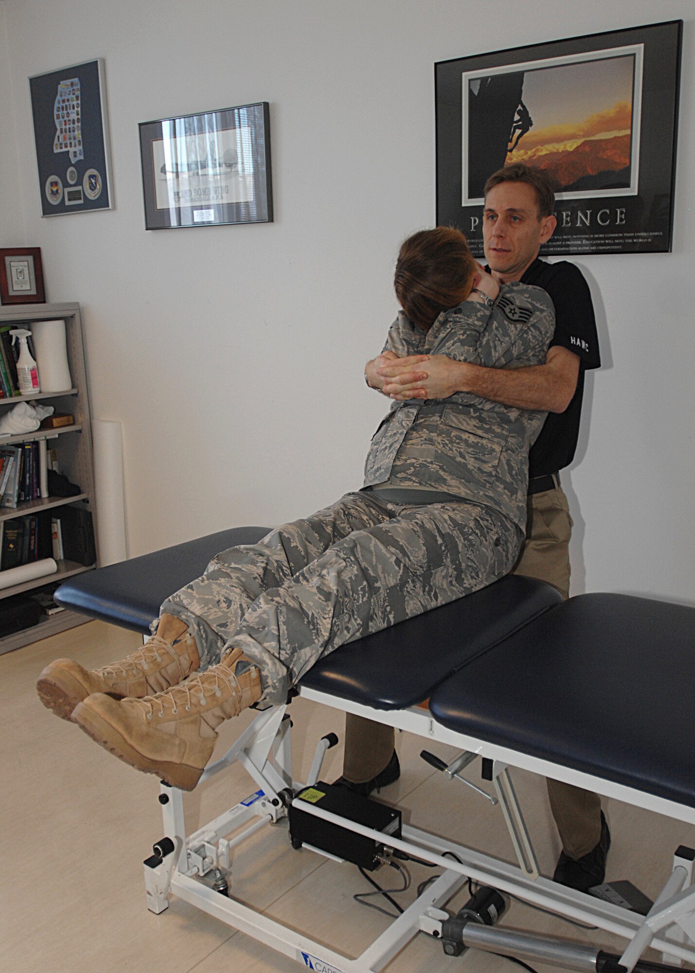 Maj. Matthew Ostler, 31st Aerospace Medicine Squadron physical therapist, performs a manual therapy manipulation technique called cervico-thoracic junction gapping on Staff Sgt. Samantha Gray, 31st AMDS, at the Aviano Health and Wellness.  This technique is used to decrease pain, increase range of motion and improve function.  (U.S. Air Force photo/Senior Airman Tabitha M. Mans)