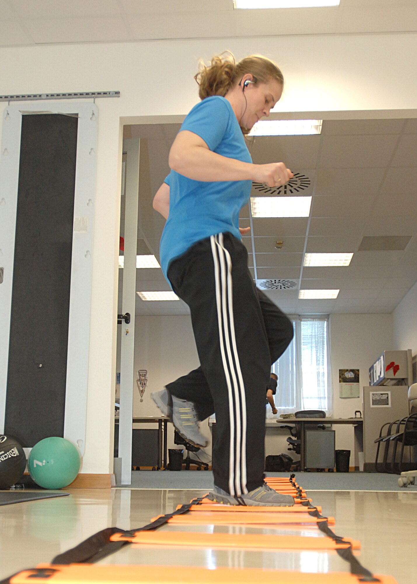 Tech. Sgt. Heather Geer, 31st Security Forces Squadron, performs an agility drill with a ladder at the Aviano Health and Wellness Center.  This exercise is used to improve strength and function.    (U.S. Air Force photo/Senior Airman Tabitha M. Mans)