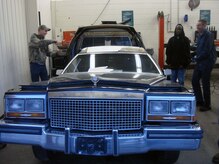 Senior Airman Ryan Reese, left, Airman 1st Class Anthony Burdett and Tech. Sgt. Barry Rolland, right, talk about the hearse which was split in half to be redesigned into a mobile training aid here recently. The Airmen volunteered more than 120 hours total to complete the project. Sergeant Rolland and Airmen Reese and Burdett are special vehicle maintainers with the 628th Logistics Readiness Squadron. (Courtesy photo)