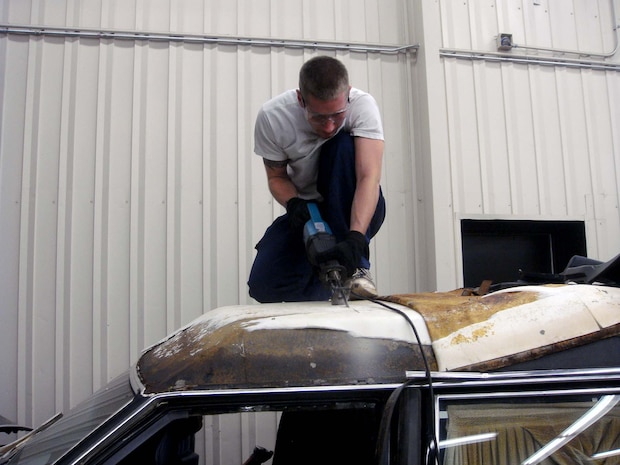 Airman 1st Class Erik Bickmore makes a cut across the roof of an old hearse donated to the base honor guard here recently. Airman Bickmore, along with members of the 628th Logistics Readiness Squadron, worked for several weeks to transform the hearse into a mobile training aid for the base honor guard. Airman Bickmore is a fire truck mechanic with the 628 LRS. (Courtesy photo)
