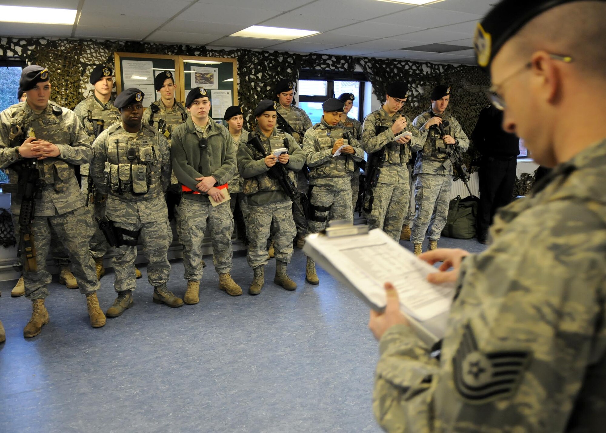 RAF MILDENHALL, England –Airmen from the 100th Security Forces Squadron listen and take notes during a safety briefing during guard mount prior to starting their shift March 1. Guard mount is a security forces shift change that includes uniform and weapons inspection, briefings and force protection updates. (U.S. Air Force photo/ Staff Sgt. Jerry Fleshman)