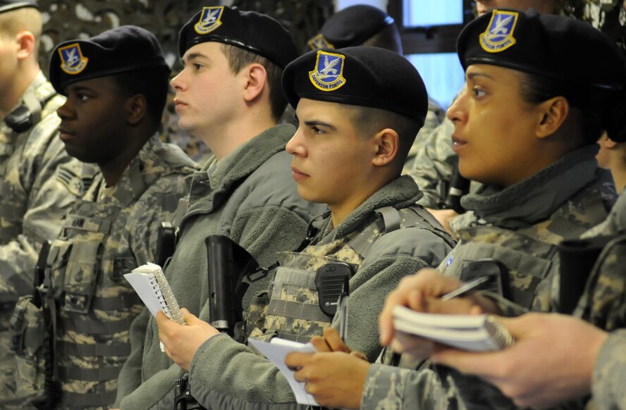 RAF MILDENHALL, England – Airmen from the 100th Security Forces Squadron listen and take notes during shift change March 1. (U.S. Air Force photo/ Staff Sgt. Jerry Fleshman)