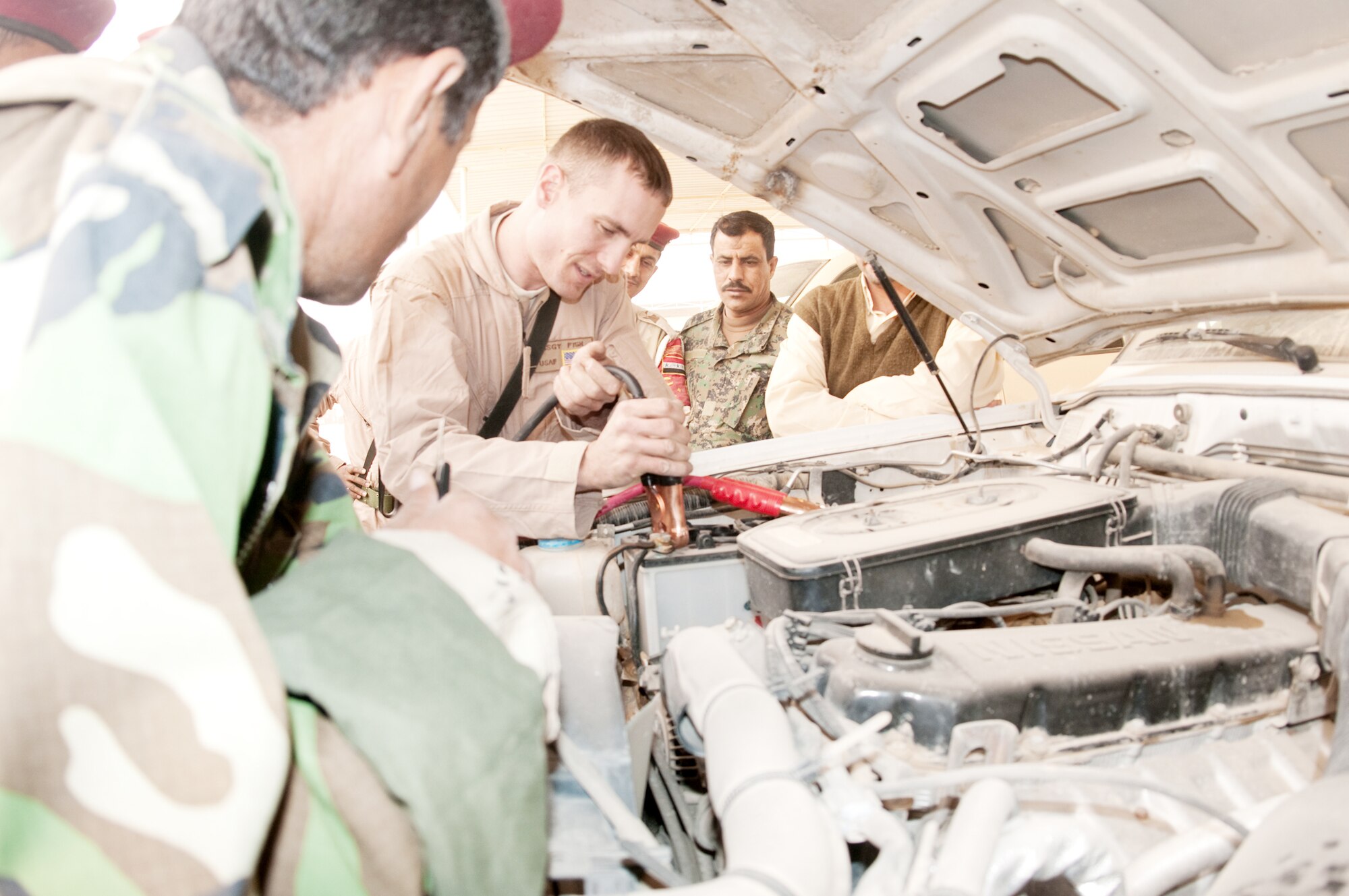 Staff Sgt. Giles Fish demonstrates to Iraqi army members how to sequentially place the jumper cables onto a charged battery during a training course given by the Logistics Military Advisory Team Feb. 22, 2010, at Camp Ur, Iraq. Sergeant Fish is assigned to the 407th Expeditionary Logistics Readiness Squadron at Ali Base, Iraq. He is deployed from Little Rock Air Force Base, Ark. (U.S. Air Force photo/Senior Master Sgt. Elizabeth Gilbert)