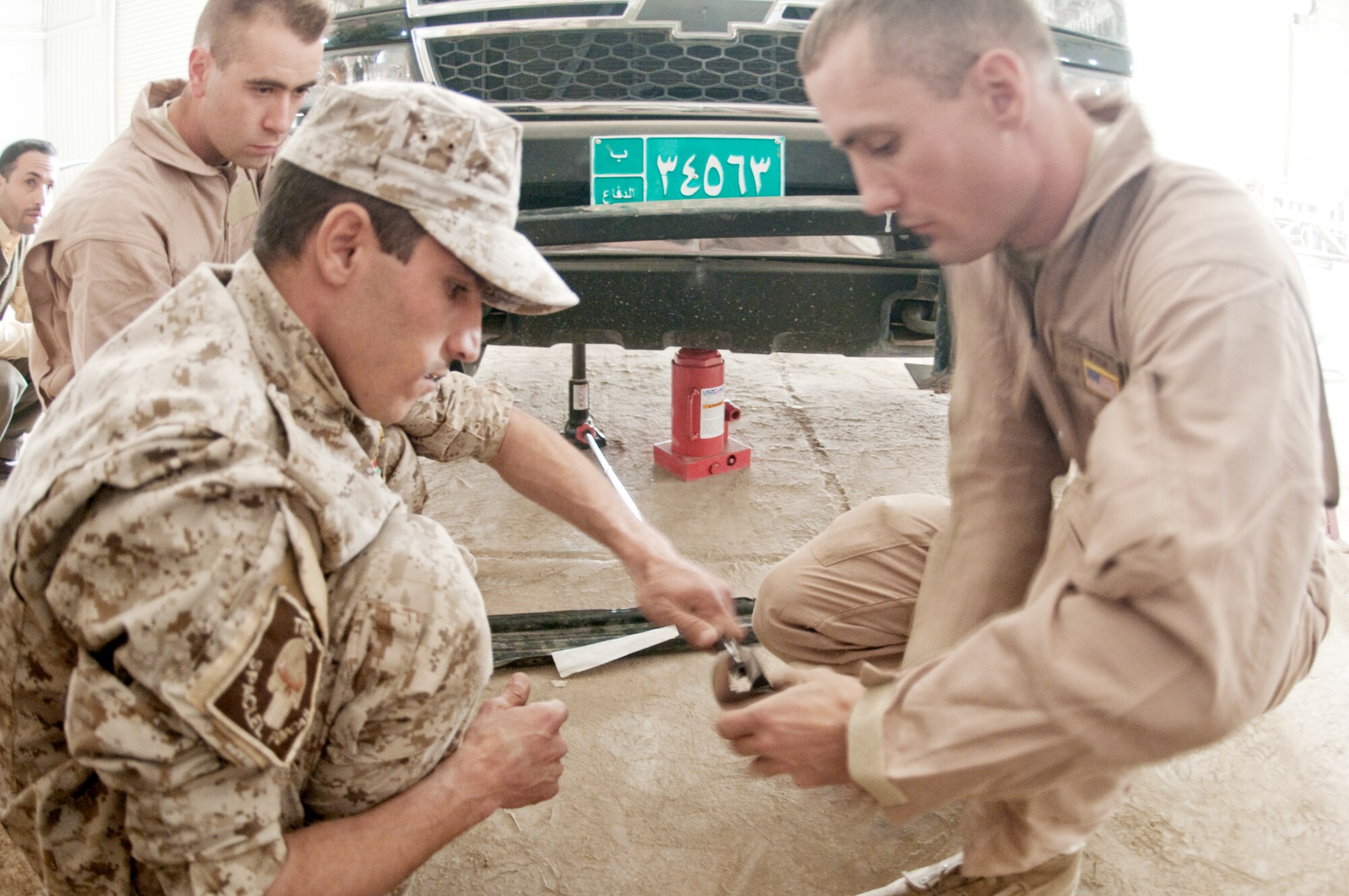 Staff Sgt. Giles Fish helps Iraqi army members prepare to elevate a truck during a training course given by the Logistics Military Advisory Team Feb. 22, 2010, at Camp Ur, Iraq. Sergeant Fish is assigned to the 407th Expeditionary Logistics Readiness Squadron at Ali Base, Iraq. He is deployed from Little Rock Air Force Base, Ark. (U.S. Air Force photo/Senior Master Sgt. Elizabeth Gilbert)