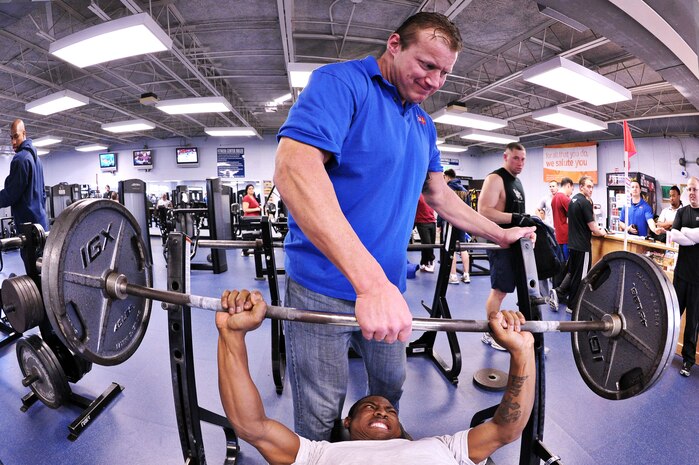 Senior Airman Rosevelt Badgett is spotted by Bob Henry during a bench press contest held at Sam's Gym at the Naval Weapons Station Charleston Feb. 26. The contest was held as part of a monthly power lifting competition intended to promote exercise and physical readiness. Airman Badgett is an aircraft electrician with the 437th Maintenance Squadron electro-environmental backshop, and Mr. Henry served as the weight lifting judge for NWS CHS Morale, Welfare and Recreation. (U.S. Navy photo/Mass Communicator 3rd Class Juan Pinalez)