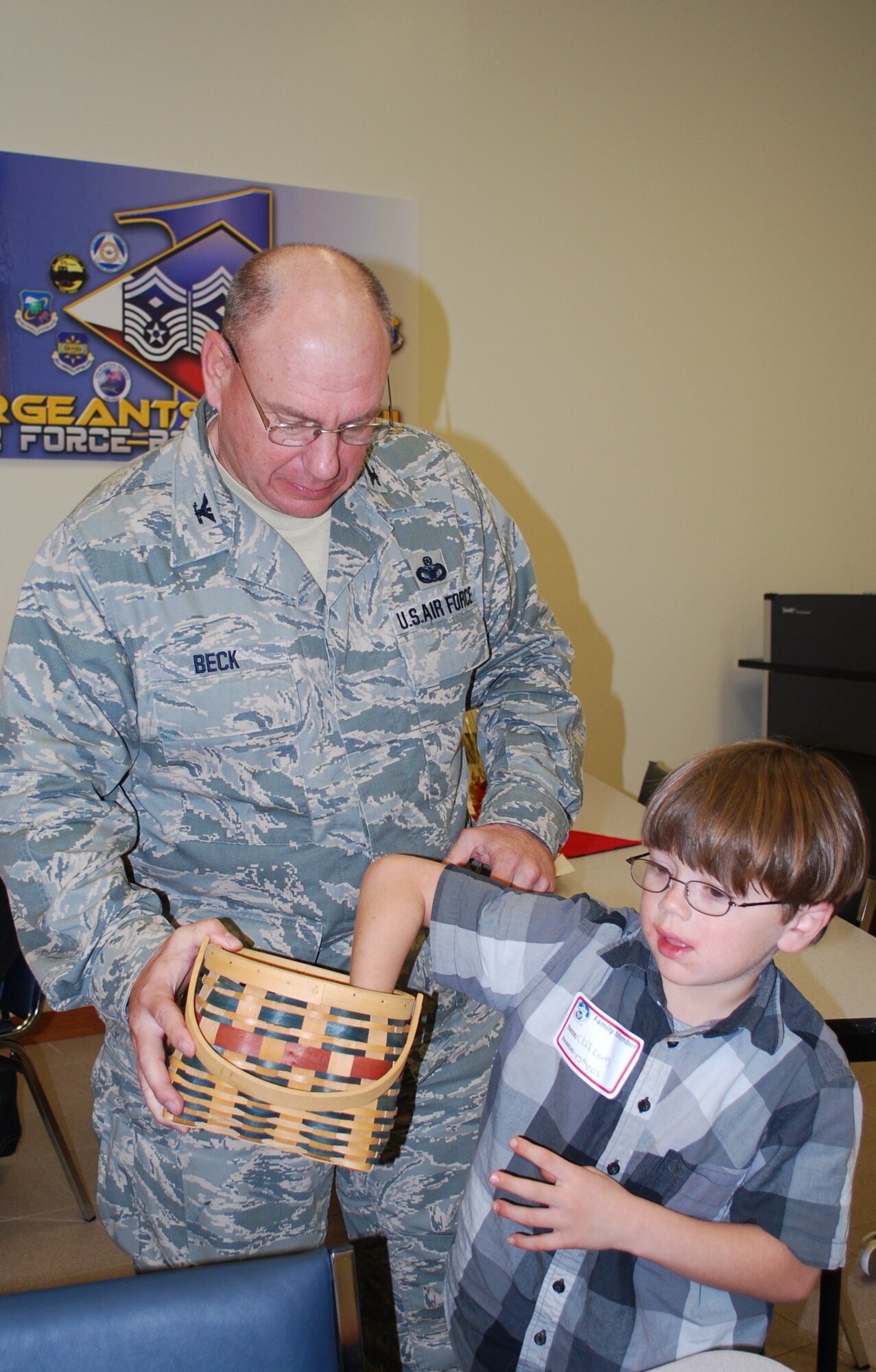 45th Mission Support Group Commander Col. Charles Beck helps 6-year old Cliff Long draw a raffle ticket during the Deployed Spouses Dinner at the Airman & Family Readiness Center here Feb. 24. Families of deployed members were invited to enjoy a chance to get out of the house and enjoy a meal prepared by volunteers from the Daughters of the American Revolution. (U.S. Air Force photo/Senior Airman David Dobrydney)