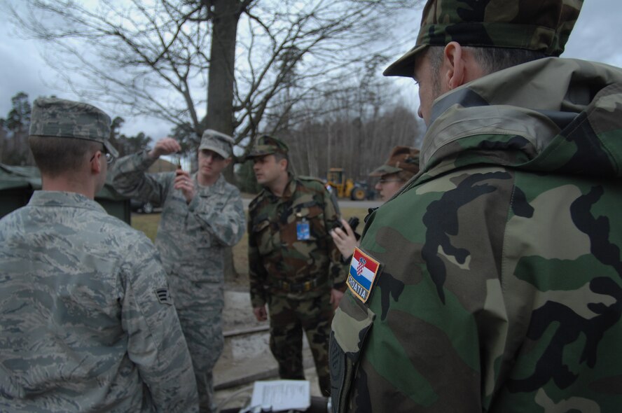 Croatian Army Soldiers observe U.S. Air Force Airmen test water ph-levels prior to using the H9518-1 reverse osmosis water purification unit. The Croatian Army for the first time was able to attend this year’s Silver Flag Exercise hosted here Feb. 21 - 28. (U.S. Air Force photo by Tech. Sgt. Michael Voss)
