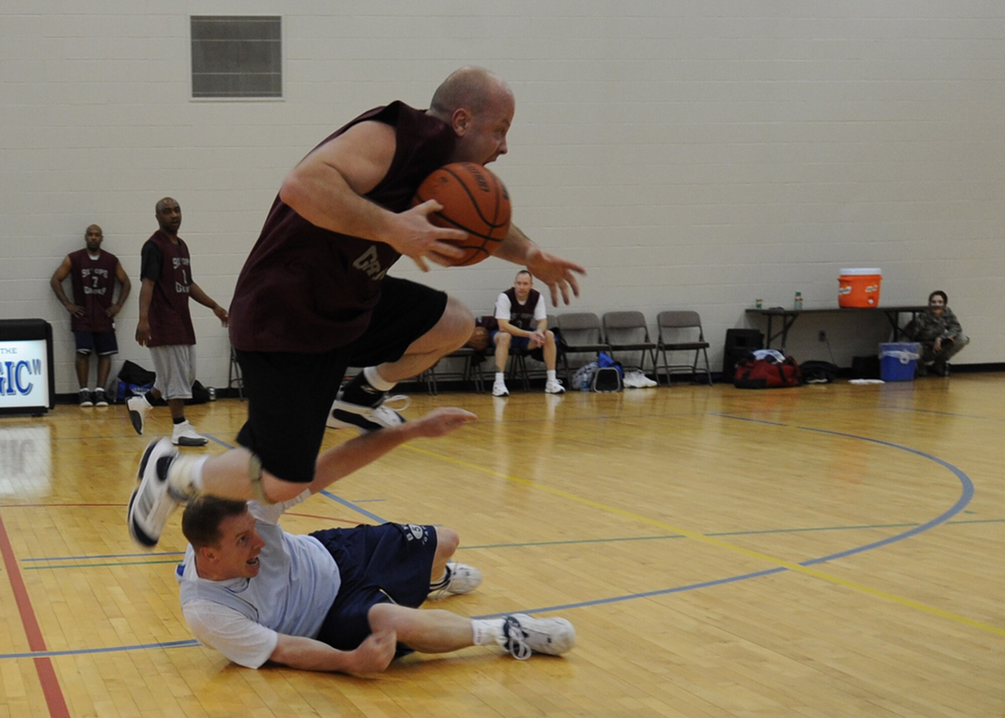 MINOT AIR FORCE BASE, N.D. – Master Sgt. Michael Harden, 91st Operations Group first sergeant, jumps over Capt. Matthew Palmer, 5th Medical Operations Squadron dentist, during the Over 30 Intramural Basketball League championship game at the McAdoo Fitness Center on Minot Air Force Base Feb. 24. The 5th Medical Group defeated the 91st Operations Group 48-30 and captured their third consecutive over 30 league championship. (U.S. Air Force photo by Senior Airman Sharida Jackson)