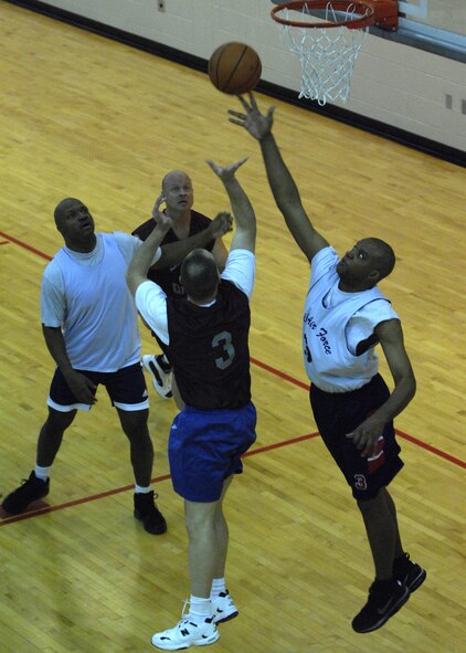 MINOT AIR FORCE BASE, N.D. -- Maj. Mark Kasayka, 91st Operations Support Squadron assistant operations officer takes a shot as Master Sgt. Troy Myles, 5th Medical Operations Squadron flight chief dental operations, goes for the block at the McAdoo Fitness Center on Minot Air Force Base Feb 24.  The 91st Operations Group battled the 5th Medical Group for the Over 30 Intramural Basketball League championship game.  The 5th MDG lost game one but ultimately prevailed in double elimination tournament by winning game two and the championship.  (U.S. Air Force photo by Airman 1st Class Ashley N. Avecilla)