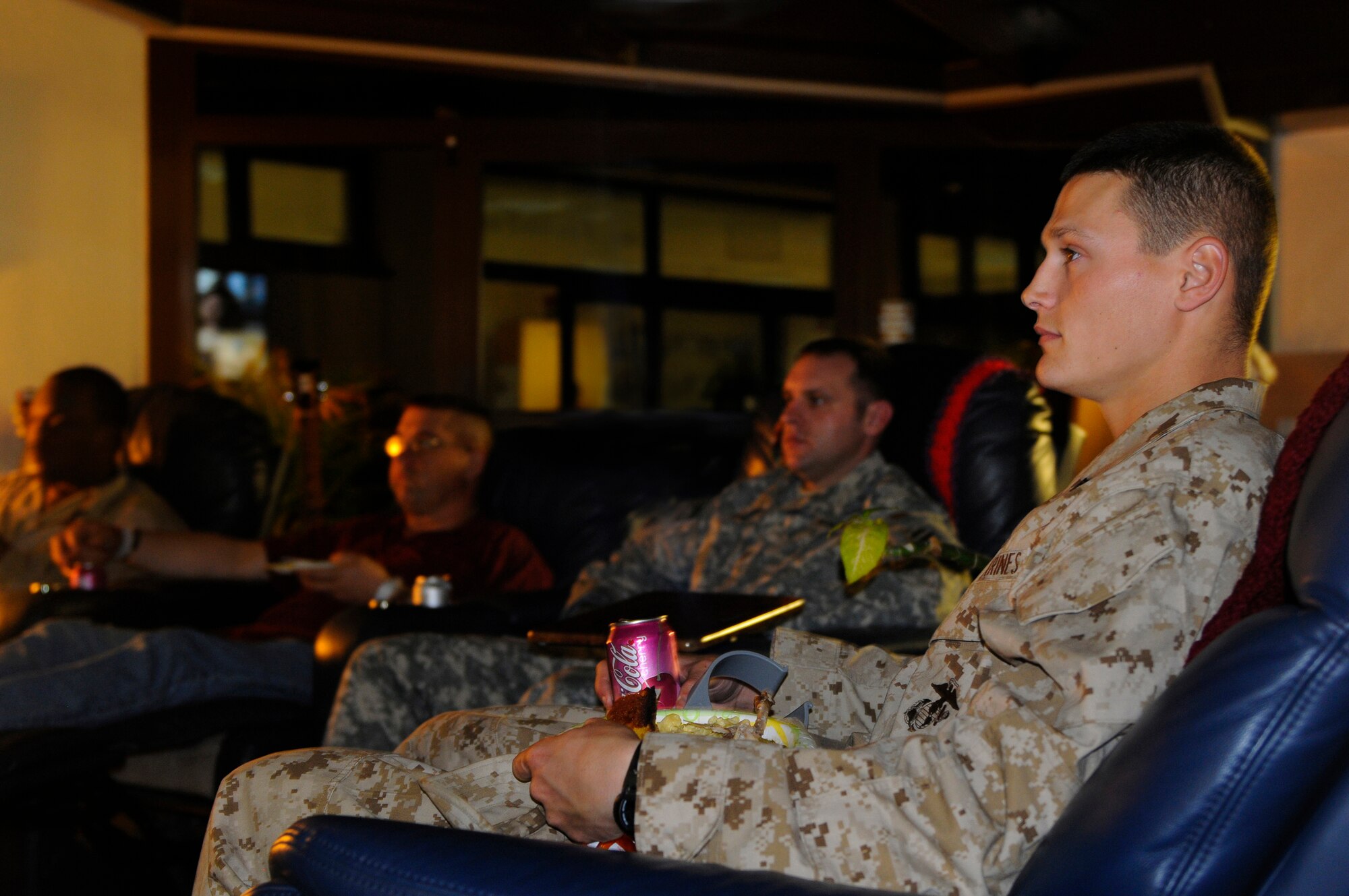 A group of servicemembers watch television during a meal at the Contingency Aeromedical Staging Facility (CASF) on Ramstein Air Base, Germany, Feb. 25, 2010. The military personnel sat down for a home cooked meal made by 'Mama' West during his stay at the CASF. (U.S. Air Force photo by Airman 1st Class Brea Miller)